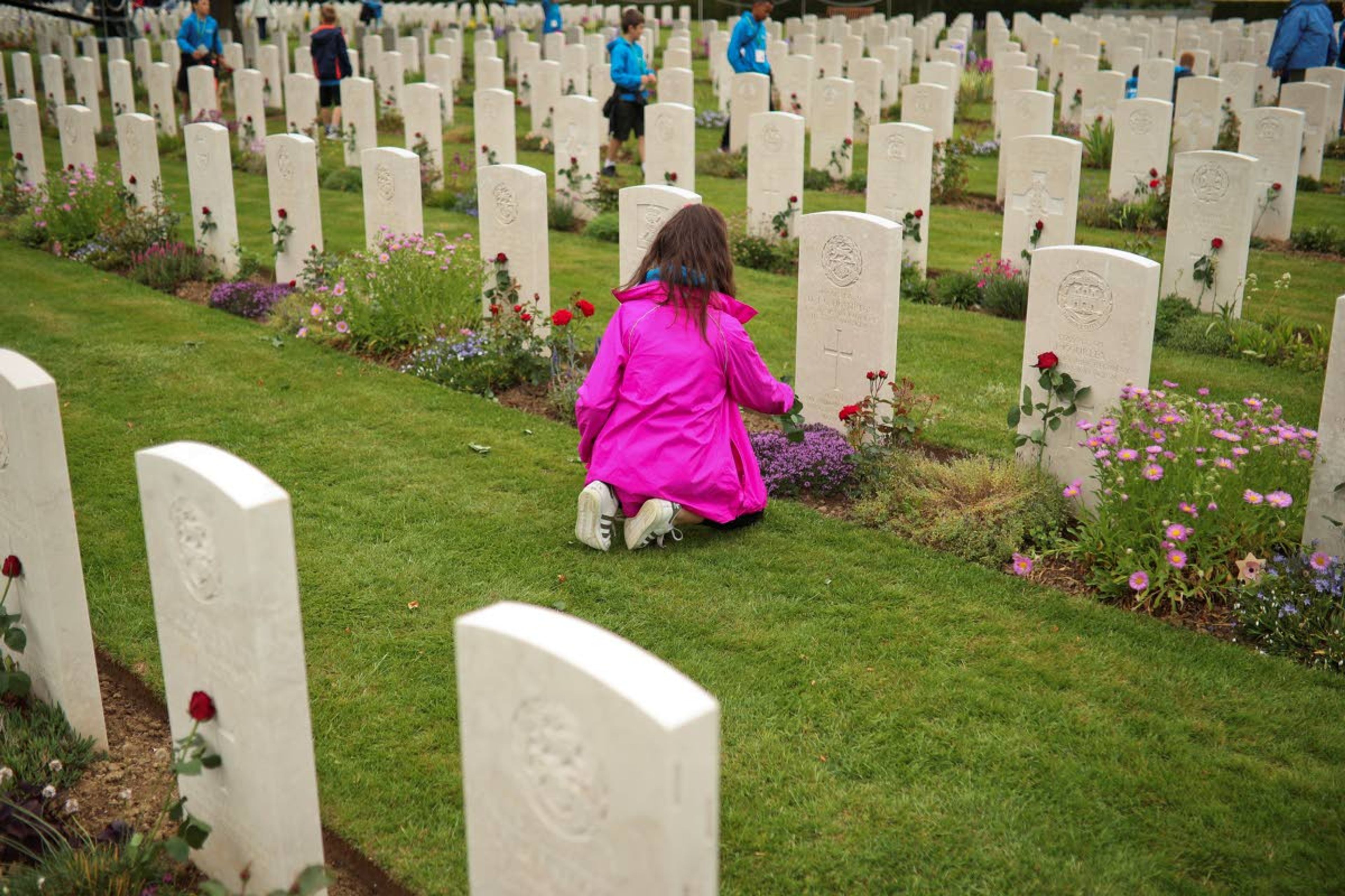 A young girl places a flower in a British soldier burial fallen during the WWII at the Bayeux War cemetery in Bayeux, Normandy region of France, Wednesday, June 5, 2019. Extensive commemorations are being held in the U.K. and France to honor the nearly 160,000 troops from Britain, the United States, Canada and other nations who landed in Normandy on June 6, 1944 in history's biggest amphibious invasion. (AP Photo/Francisco Seco)