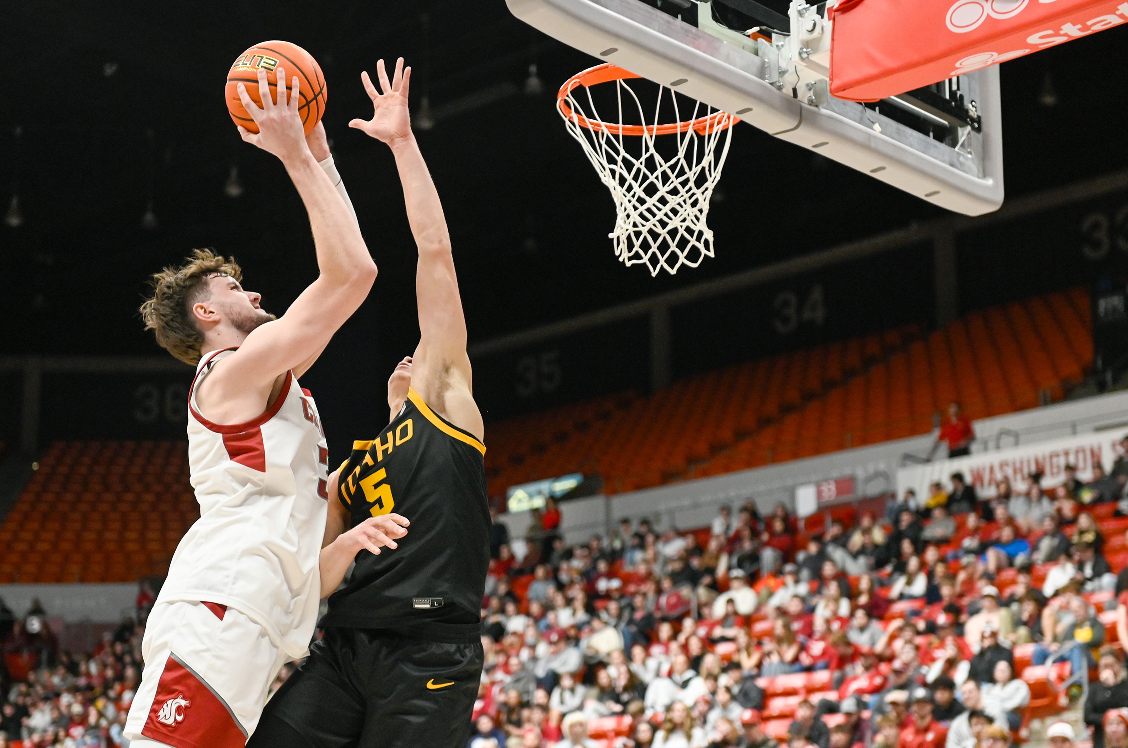 Washington State forward Ethan Price jumps for a two-point shot while being guarded by Idaho guard Isaiah Brickner Monday in Pullman.