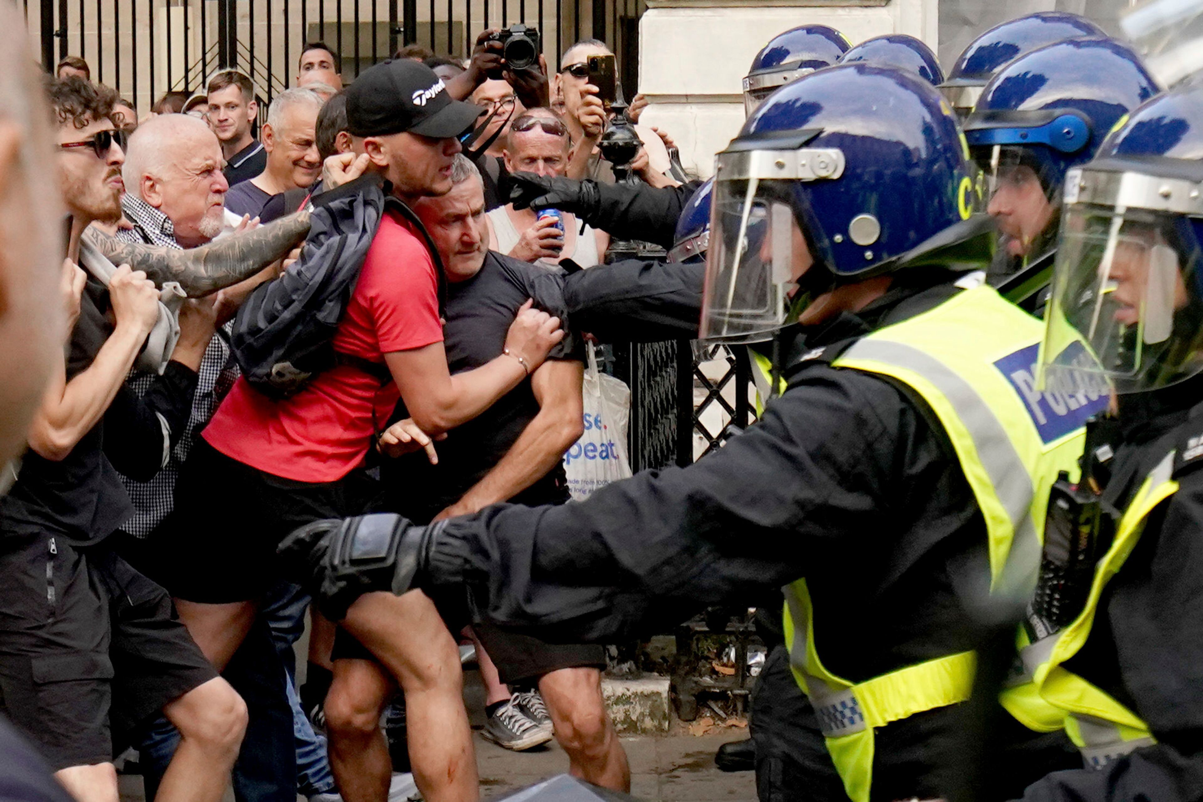 Protesters scuffle with police during the "Enough is Enough" protest in Whitehall, London, Wednesday July 31, 2024, following the fatal stabbing of three children at a Taylor Swift-themed summer holiday dance and yoga class on Monday in Southport. (Jordan Pettitt/PA via AP)