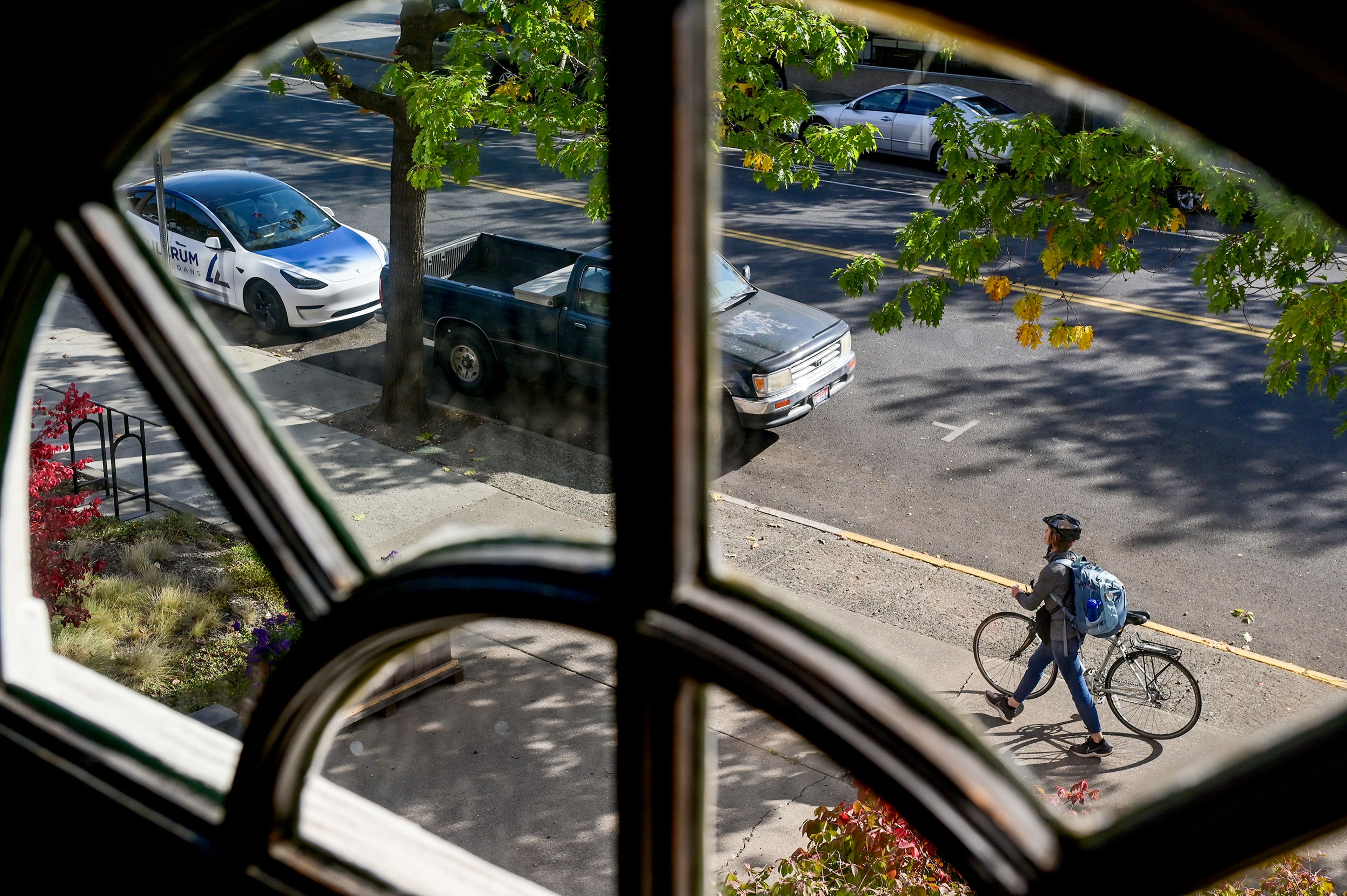 A cyclist walks their bike past Moscow City Hall in downtown Moscow.,