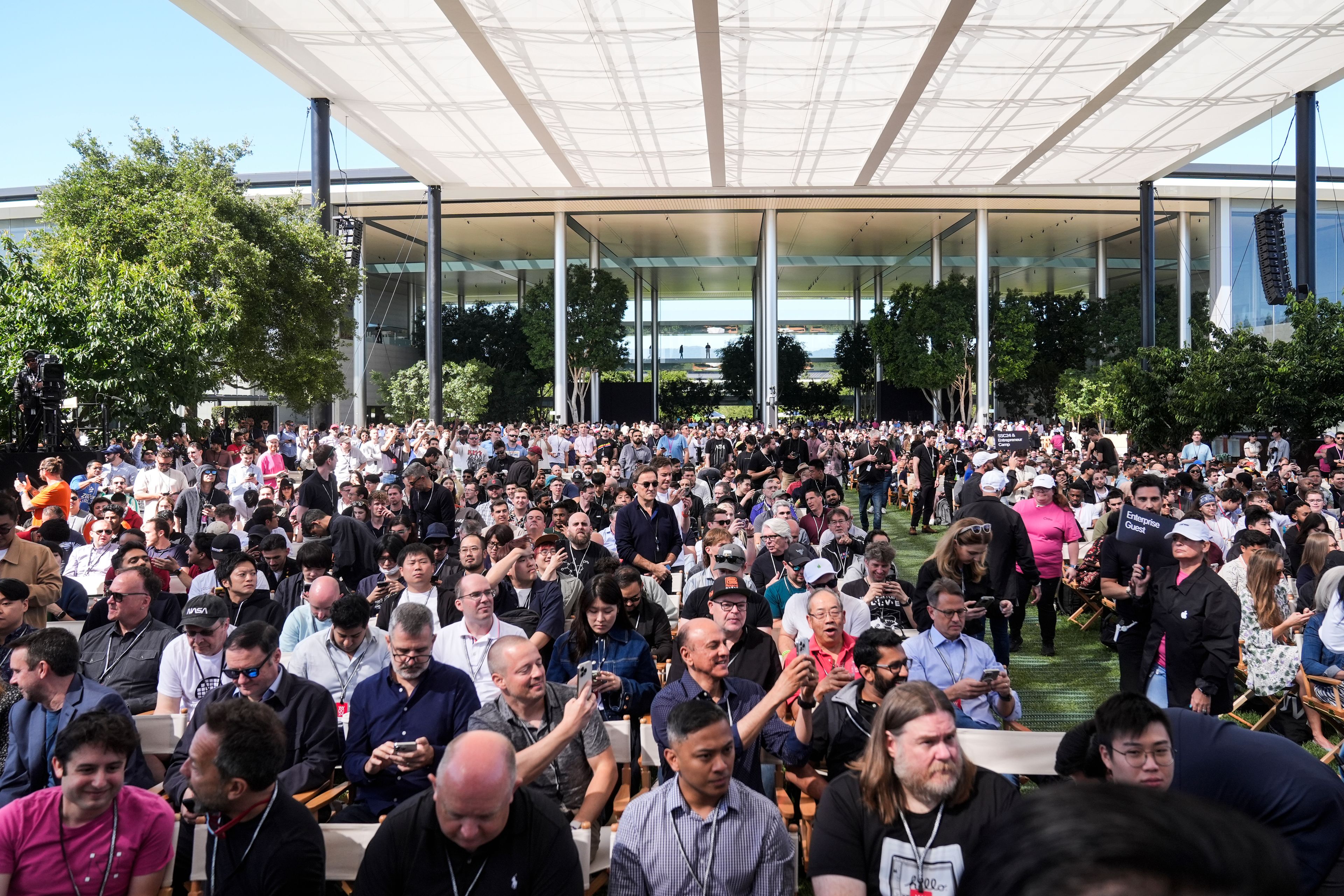 People attend an Apple event announcing new products in Cupertino, Calif., Monday, June 10, 2024.