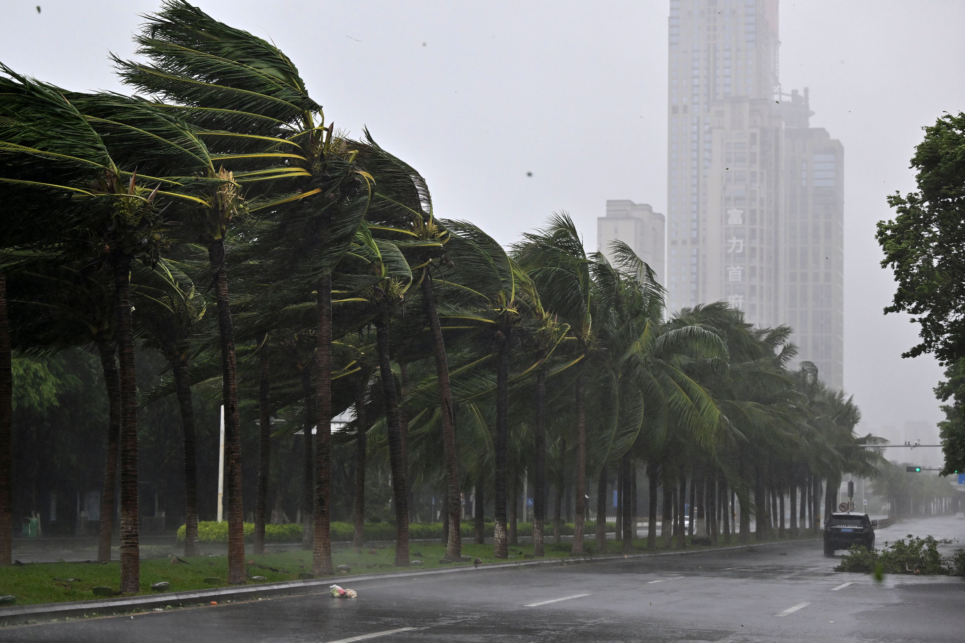 In this photo released by Xinhua News Agency, a vehicle moves past trees along a road in Haikou following the landfall of typhoon Yagi, in south China's Hainan Province, Friday, Sept. 6, 2024.