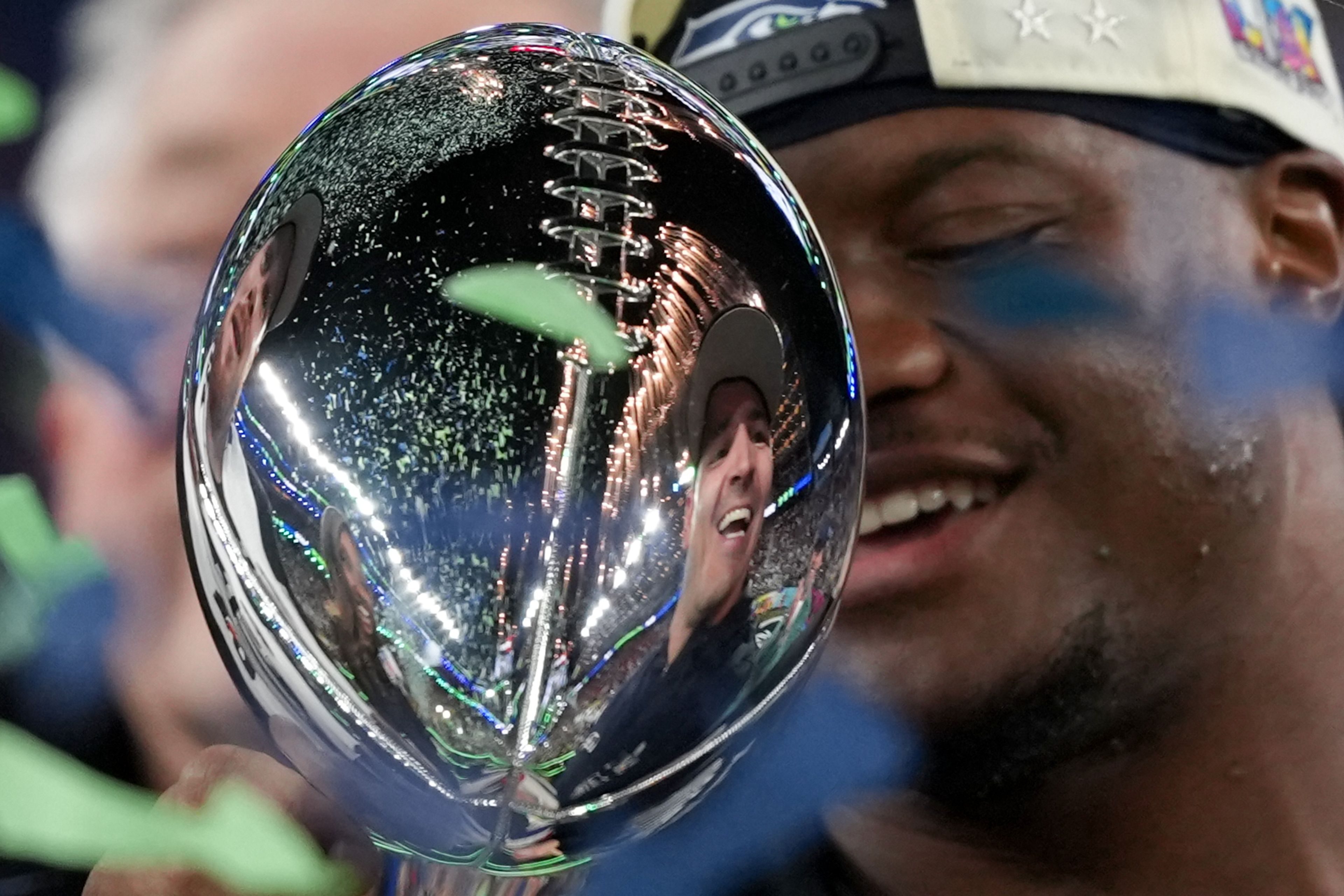 Seahawks running back and Super Bowl MVP Kenneth Walker III takes in the moment as Seahawks coach Mike Macdonald is reflected in the Lombardi Trophy after a win over the Patriots in Super Bowl 60 on Sunday in Santa Clara, Calif.