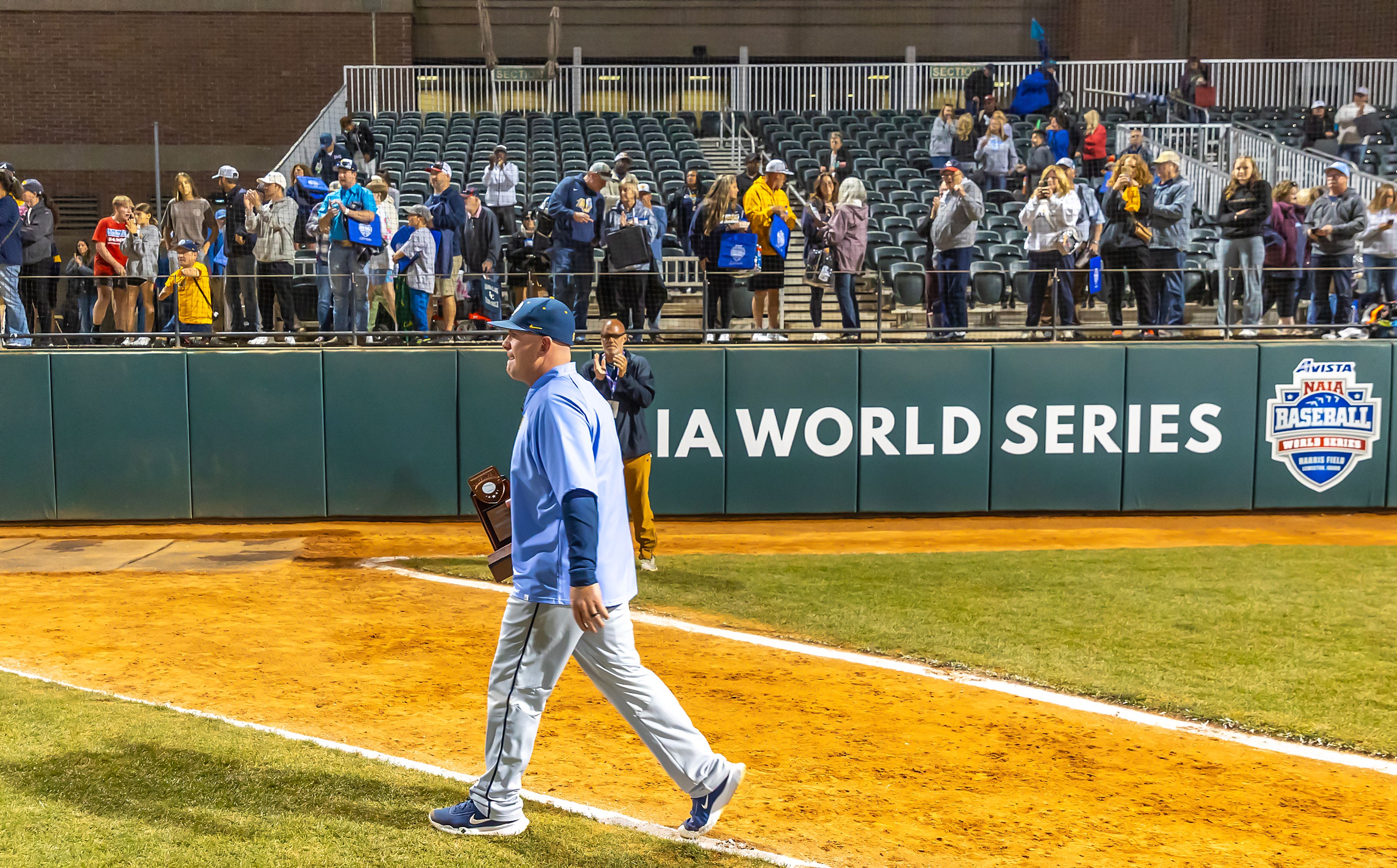 Reinhardt Head Coach Jonathan Burton walks off the field after being given the third place trophy following their loss to Tennessee Wesleyan in Game 18 of the NAIA World Series at Harris Field Thursday in Lewiston.