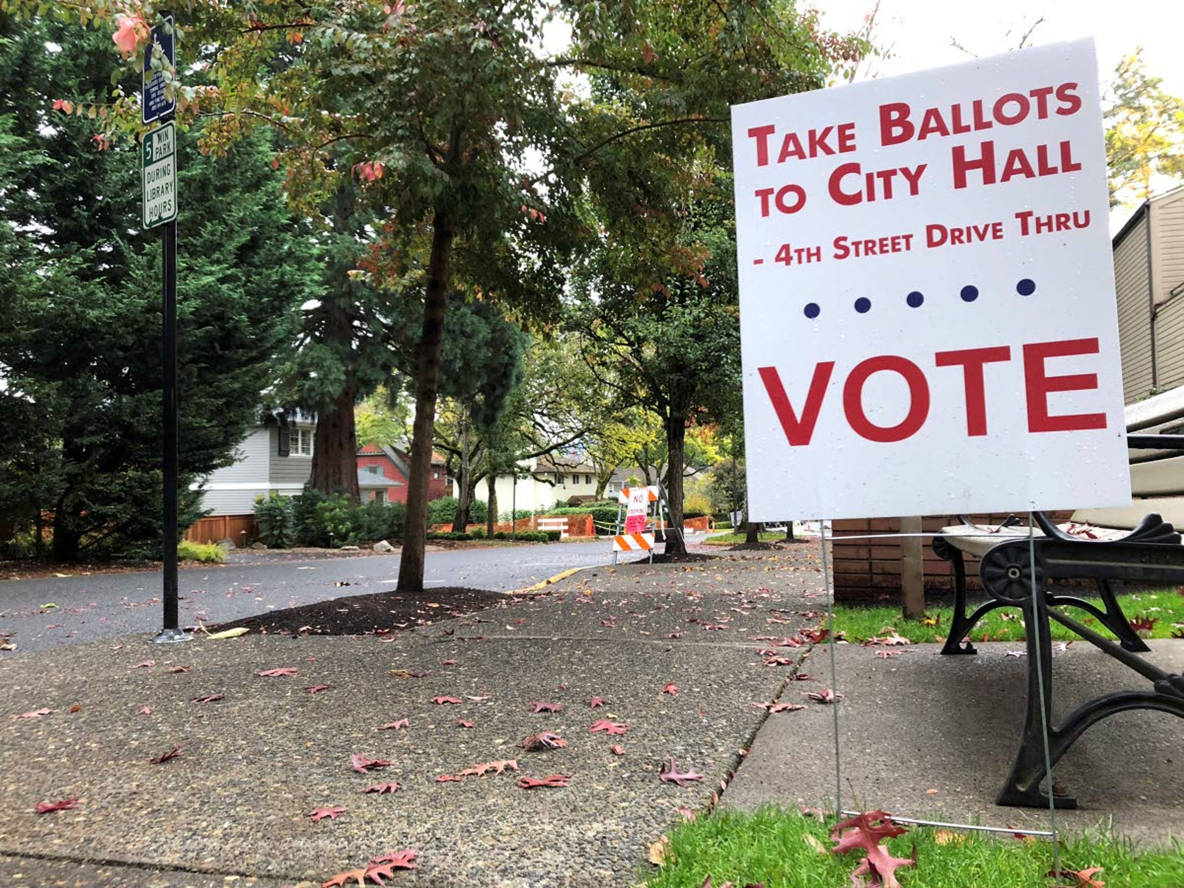 A sidewalk sign in front of the library Wednesday in Lake Oswego, Ore., directs voters where to vote.