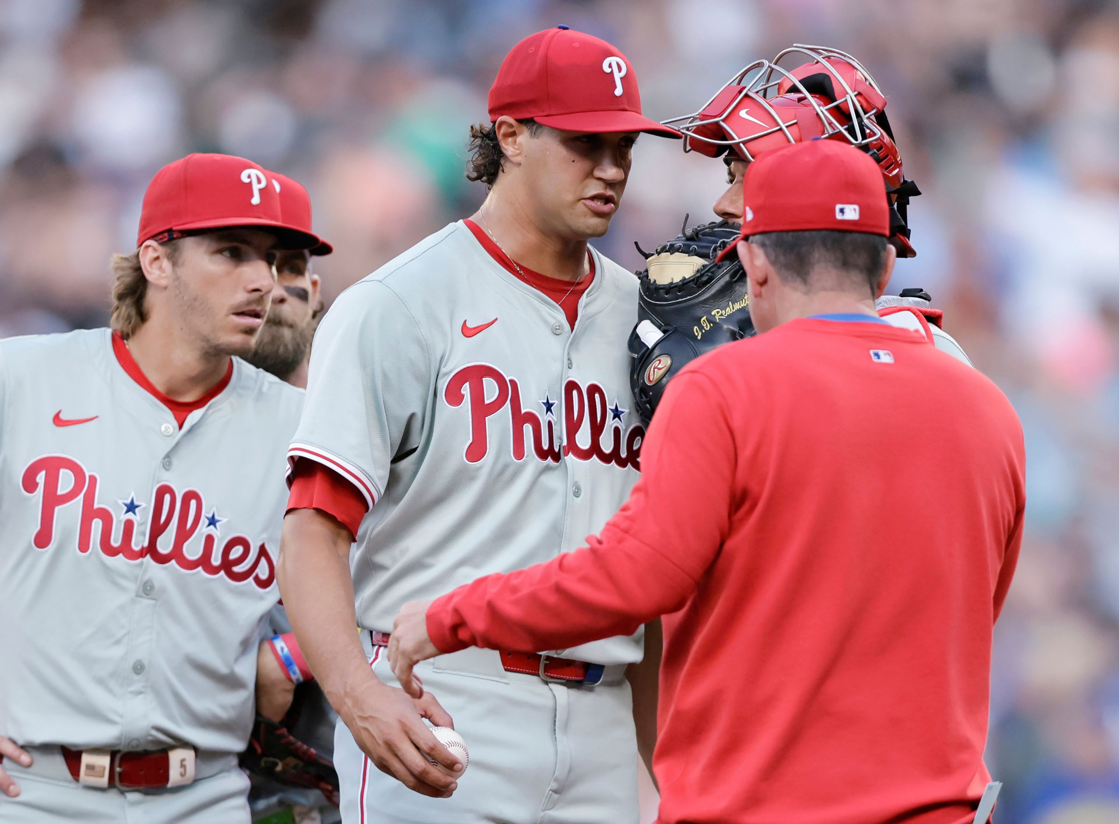 Philadelphia Phillies starting pitcher Tyler Phillips, center, prepares to hand the ball to manager Rob Thomson, right, as he is relieved during the second inning after giving up a grand slam against the Seattle Mariners in a baseball game, Friday, Aug. 2, 2024, in Seattle. (AP Photo/John Froschauer)