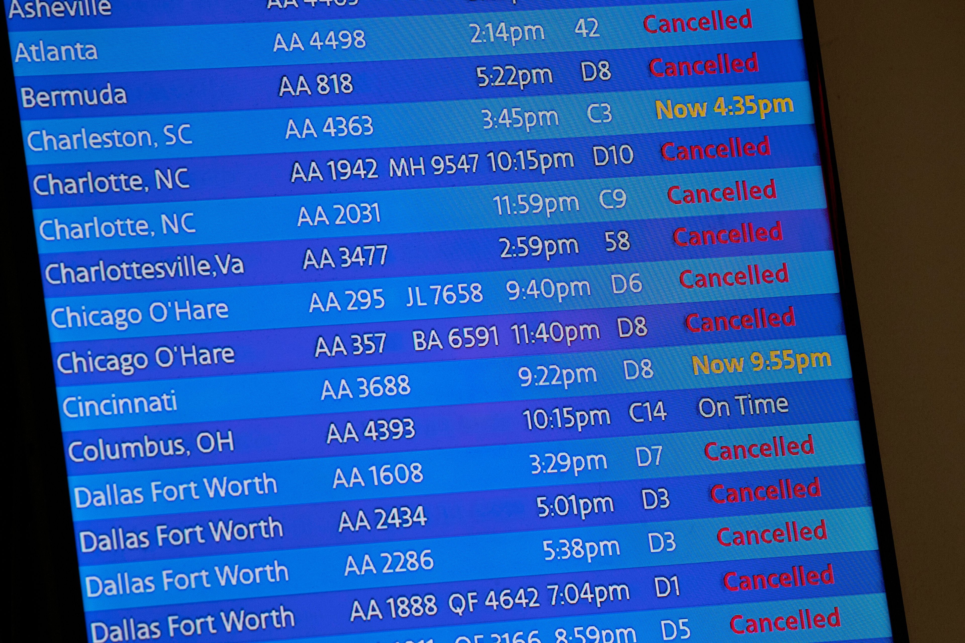 The arrivals board at the American Airlines terminal at LaGuardia Airport displays flights that have been canceled or delayed and one that is on time in 2020 in New York.