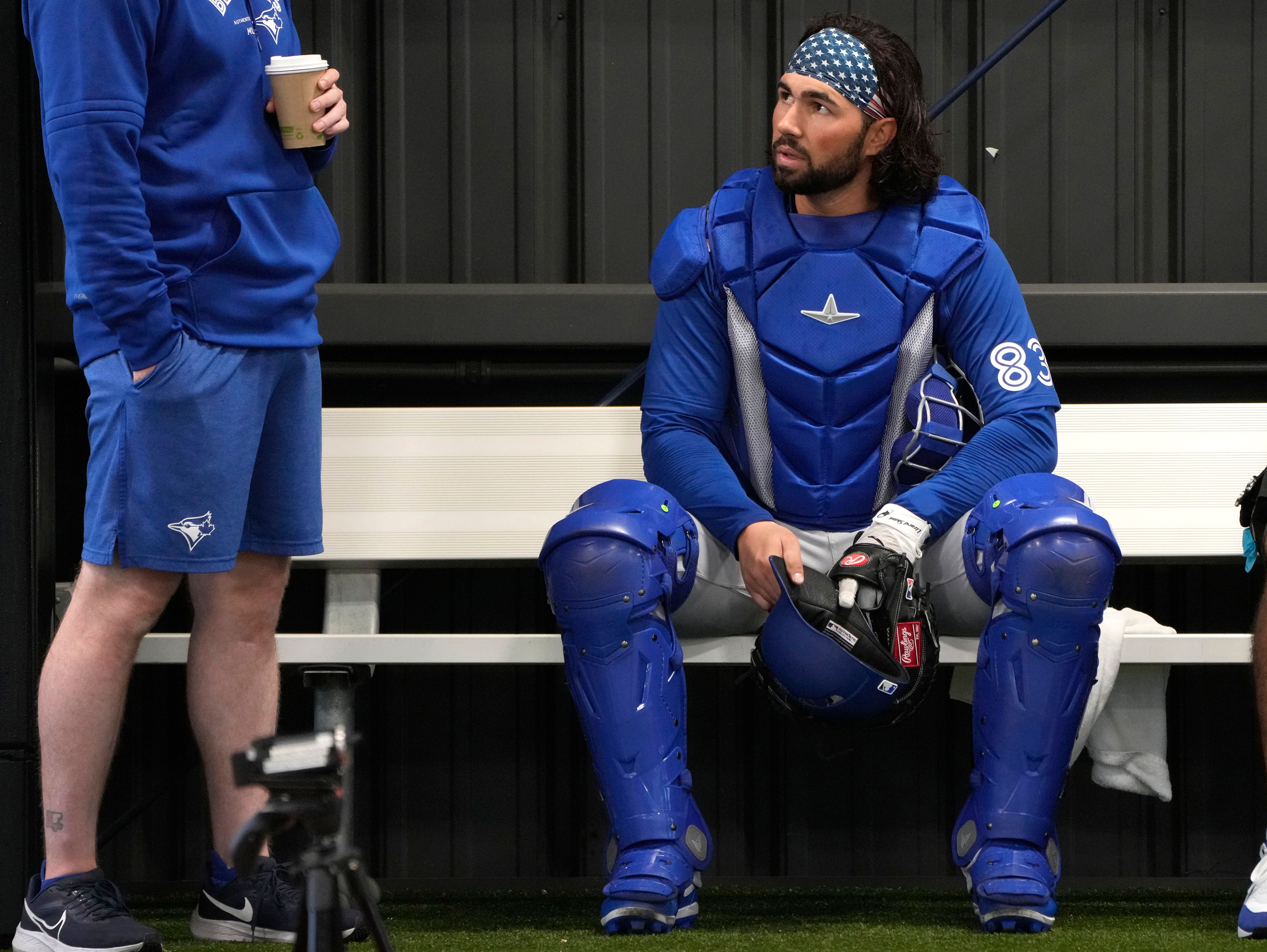 FILE - Toronto Blue Jays catcher Payton Henry, right, sits in the bullpen during a baseball spring training workout Feb. 18, 2024, in Dunedin, Fla. Current Buffalo Bisons catcher Henry was hospitalized Friday, May 31, 2024, after he was struck by a batter's backswing and carted off the field on a stretcher.