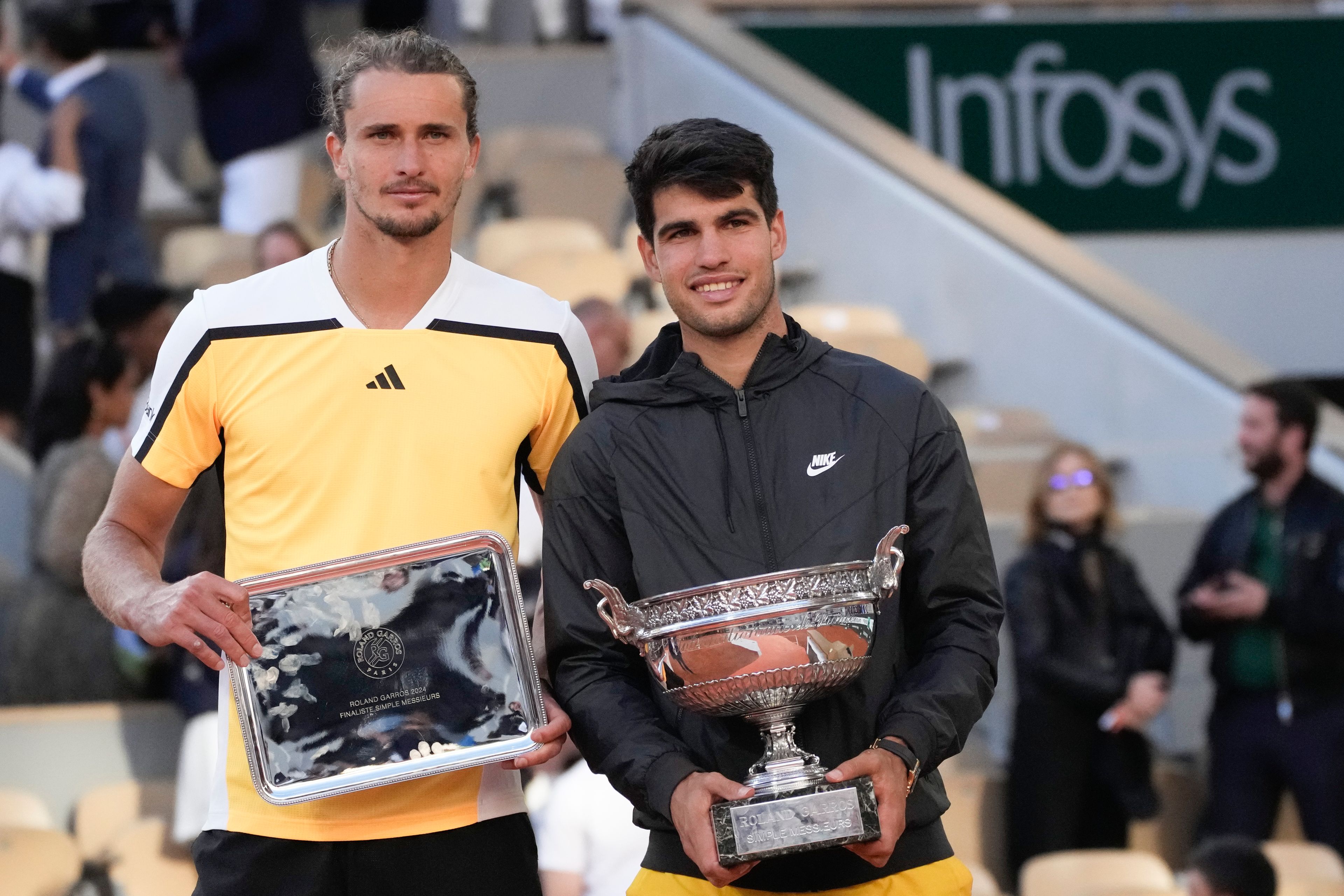 Spain's Carlos Alcaraz, right, holds the trophy after winning the men's final of the French Open tennis tournament against Germany's Alexander Zverev, left, at the Roland Garros stadium in Paris, France, Sunday, June 9, 2024.