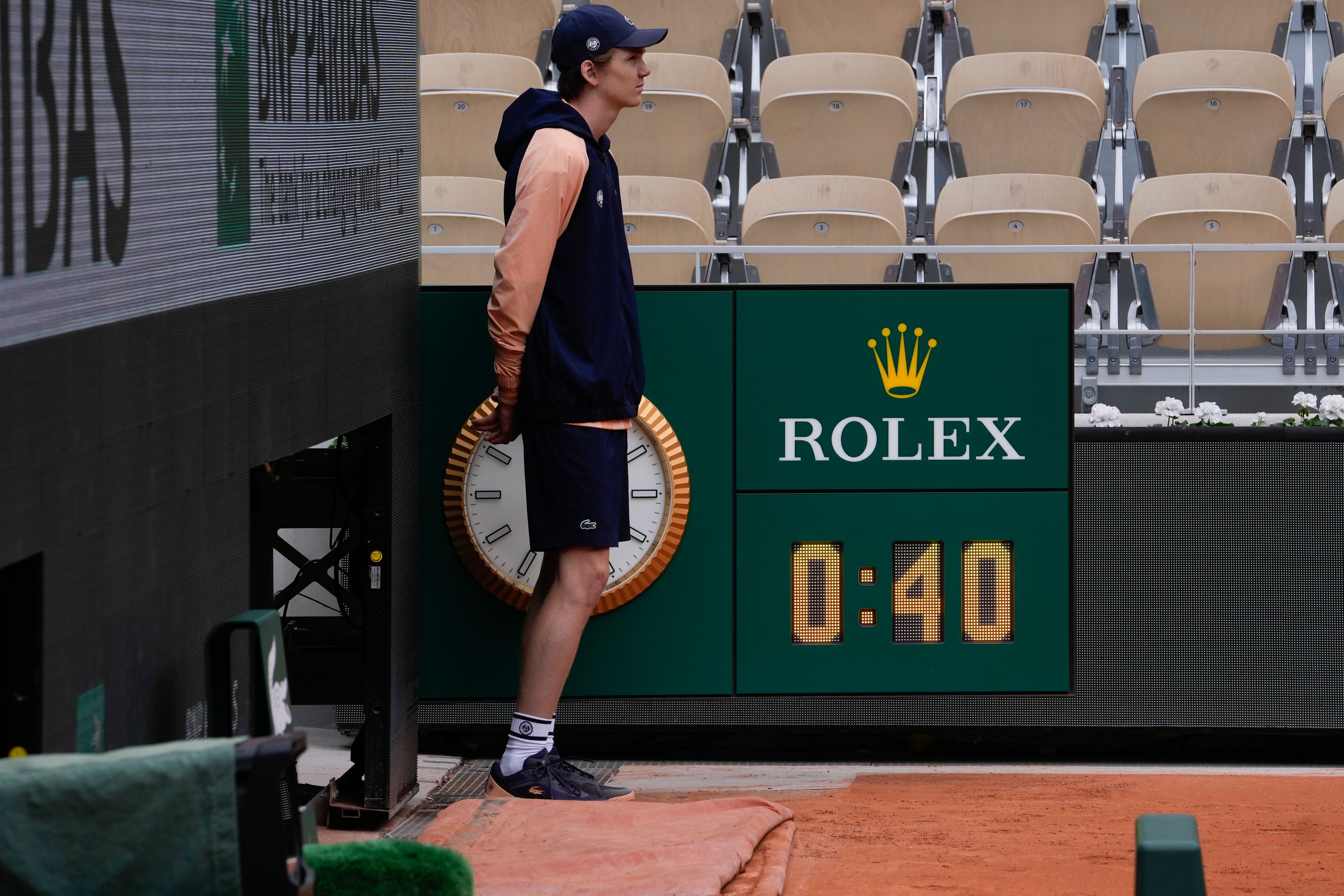 A ball kid stand next the sign showing the match time Poland's Iga Swiatek needed to defeat Russia's Anastasia Potapova in two sets 6-0, 6-0, during their fourth round match of the French Open tennis tournament at the Roland Garros stadium in Paris, Sunday, June 2, 2024.