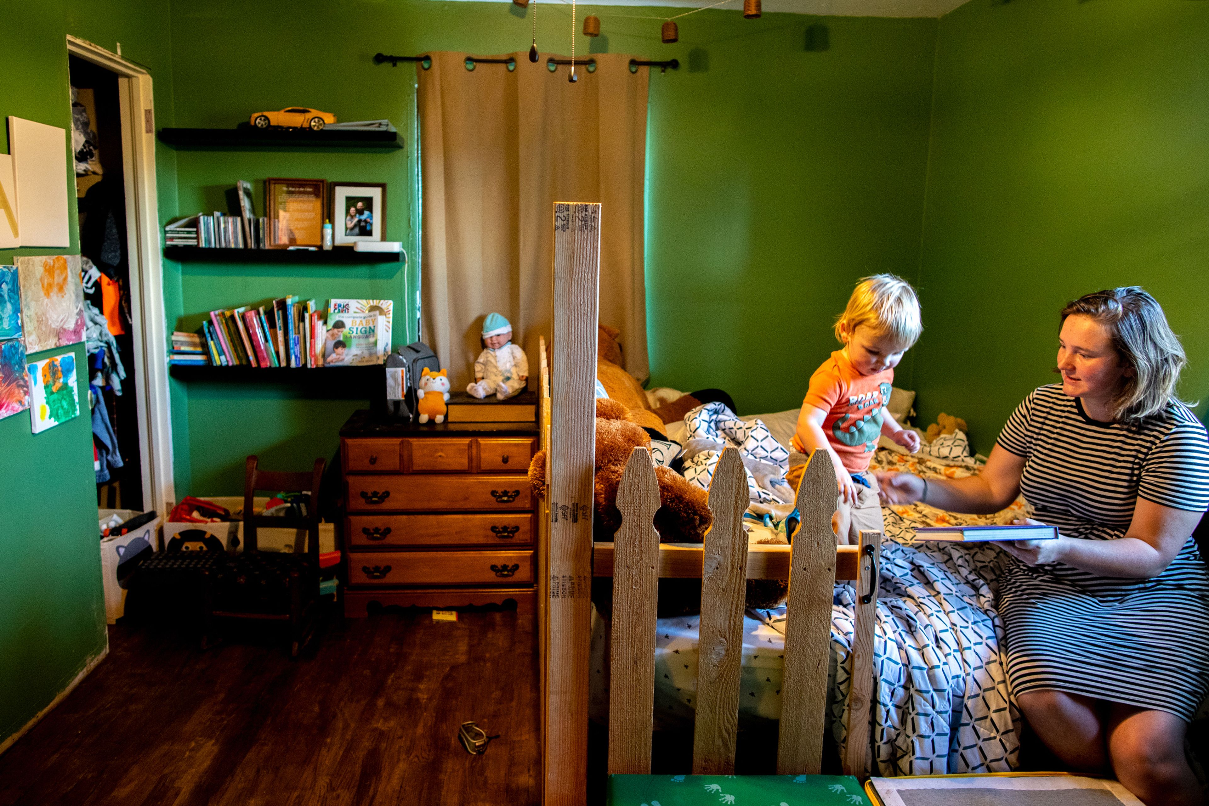 Michaela Johnson shows her son Atlas some of her favorite books in the 19-month-old’s room Tuesday at the Johnson’s home in Lewiston.