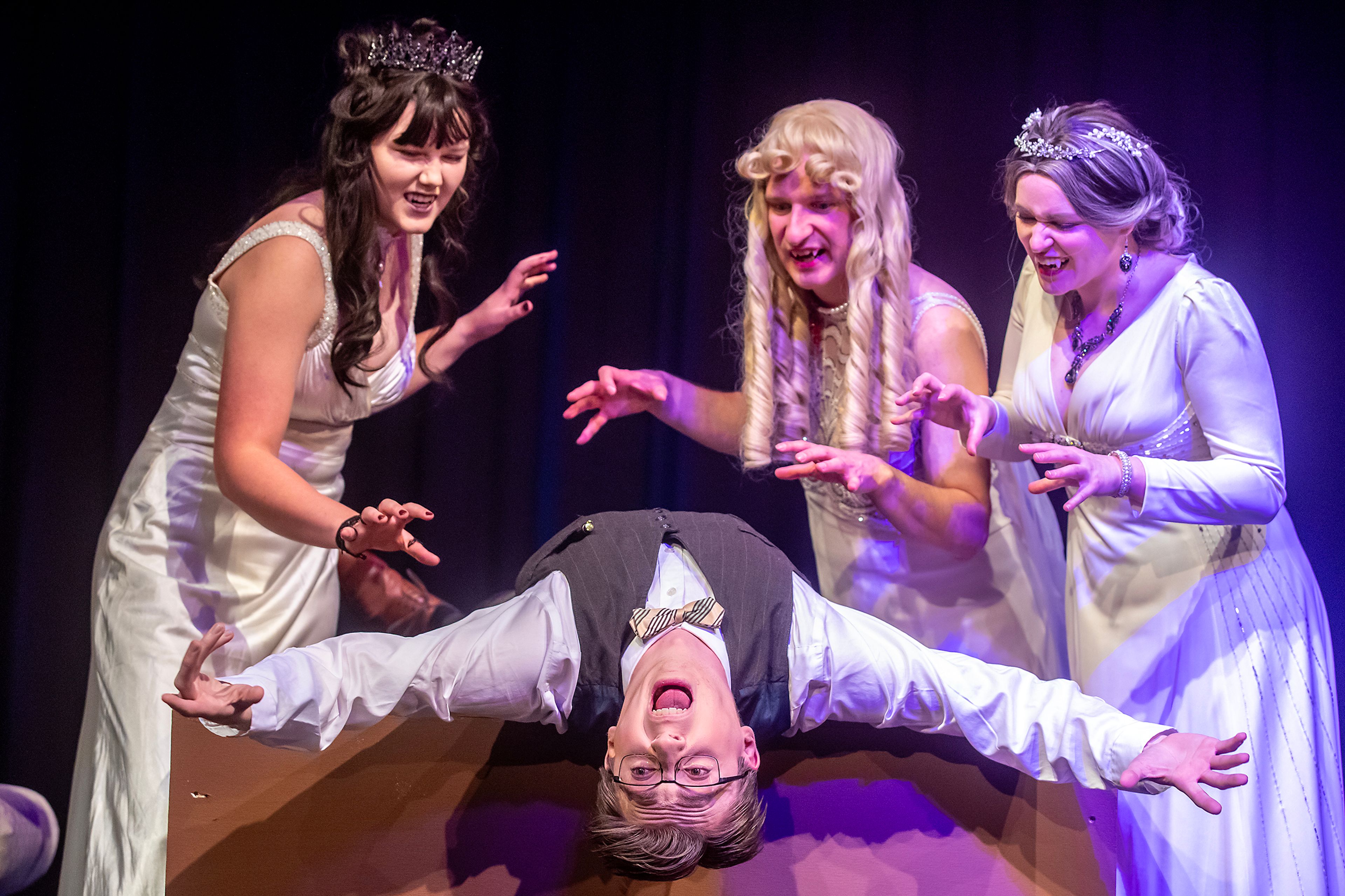 Cooper Knutson, playing Jonathan Harker, is descended upon by the brides of Dracula played by Rachel Sila, from left, Travis Osburn and Taylor Wilkins for the Lewiston Civic Theatre production of �Dracula� Tuesday, Sept. 17, in Lewiston.,