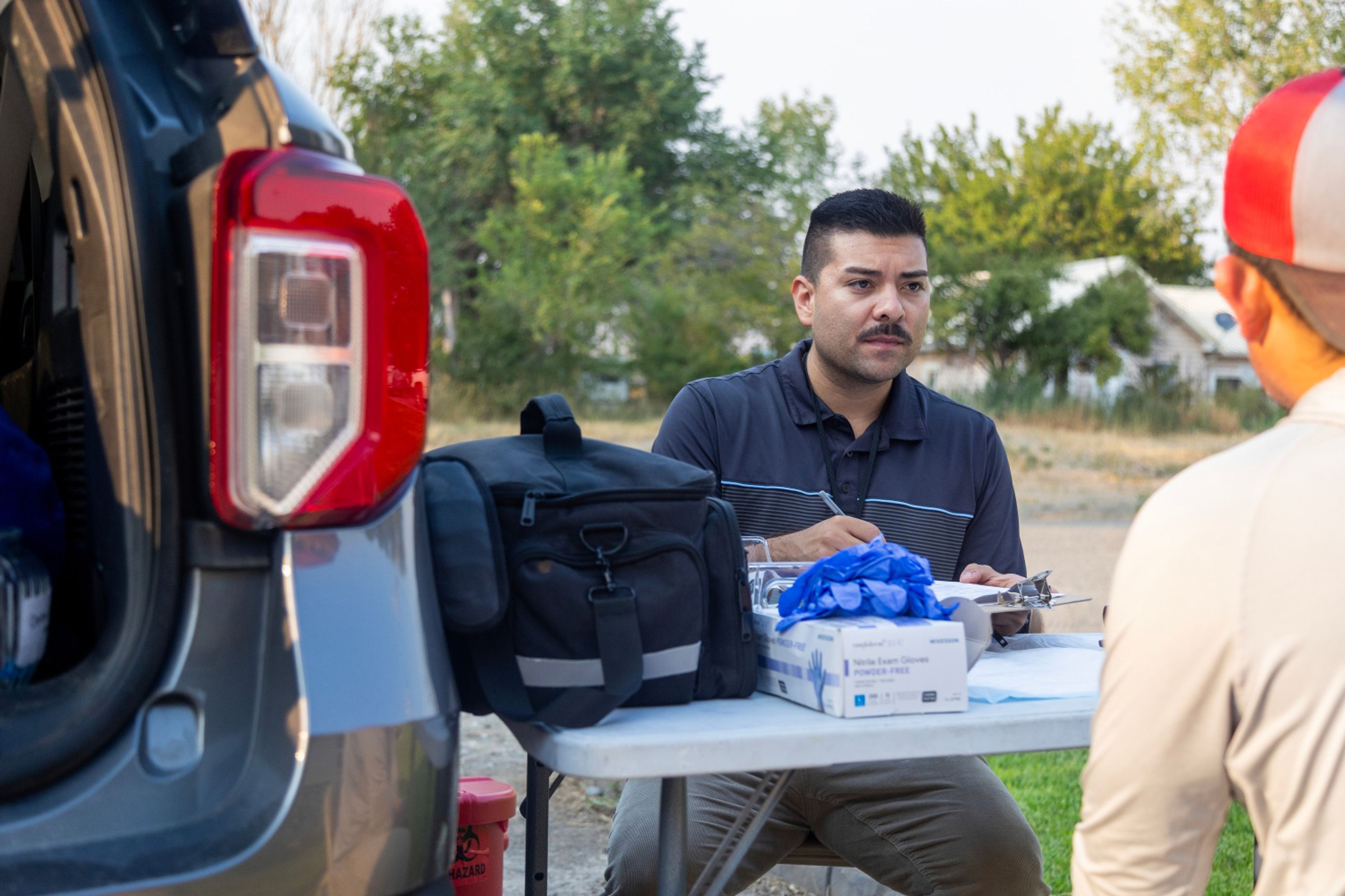 Alex Dominguez with Idaho Central District Health performs health tests for agricultural workers in Hammett, Idaho. The tests are intended to help the farmworkers better understand how hot weather can affect them.