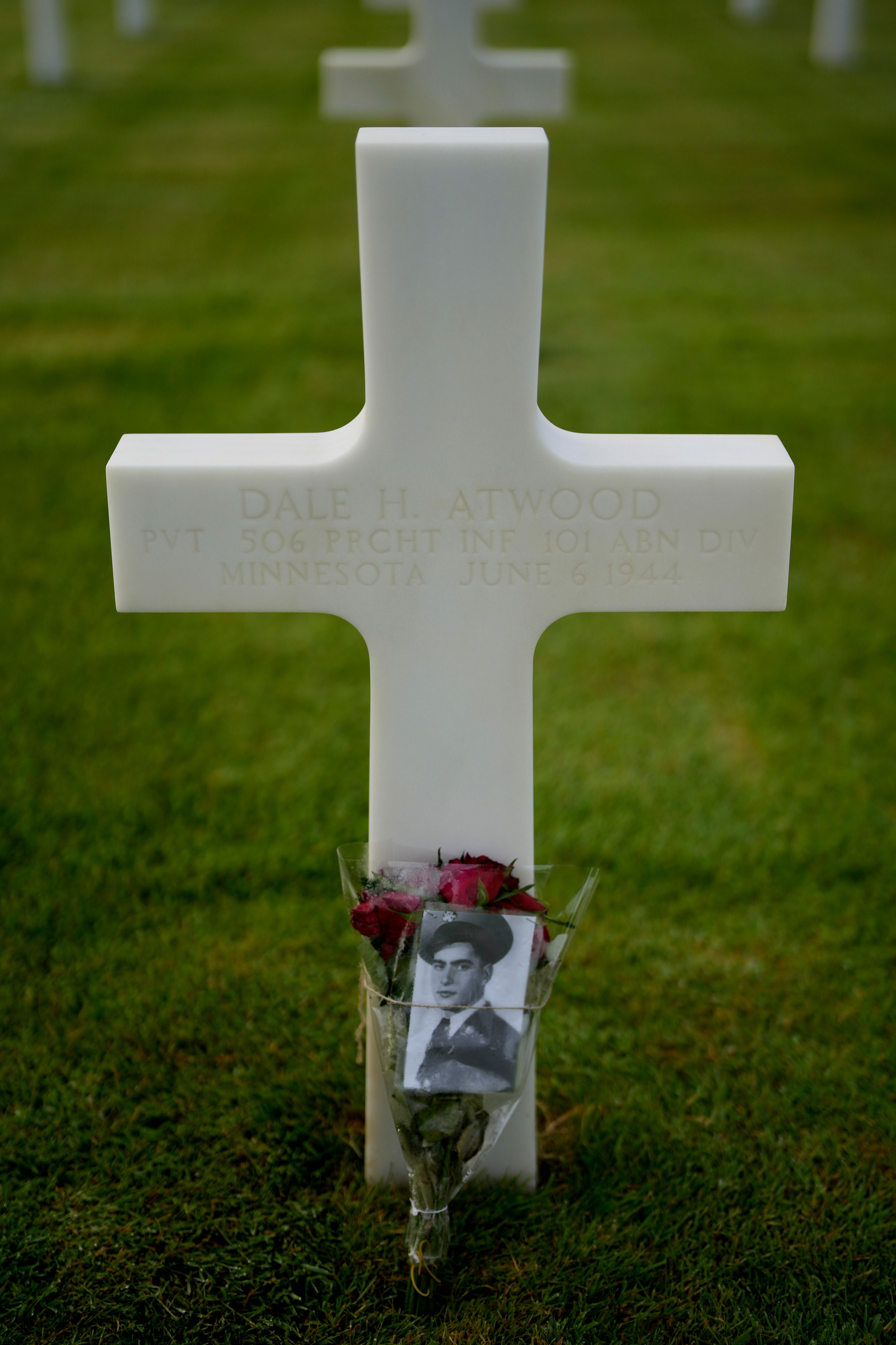 A photograph and flowers are left at the grave of US World War II soldier Dale Atwood at the Normandy American Cemetery in Colleville-sur-Mer, France, Tuesday, June 4, 2024. World War II veterans from across the United States as well as Britain and Canada are in Normandy this week to mark 80 years since the D-Day landings that helped lead to Hitler's defeat. (AP Photo/Virginia Mayo)