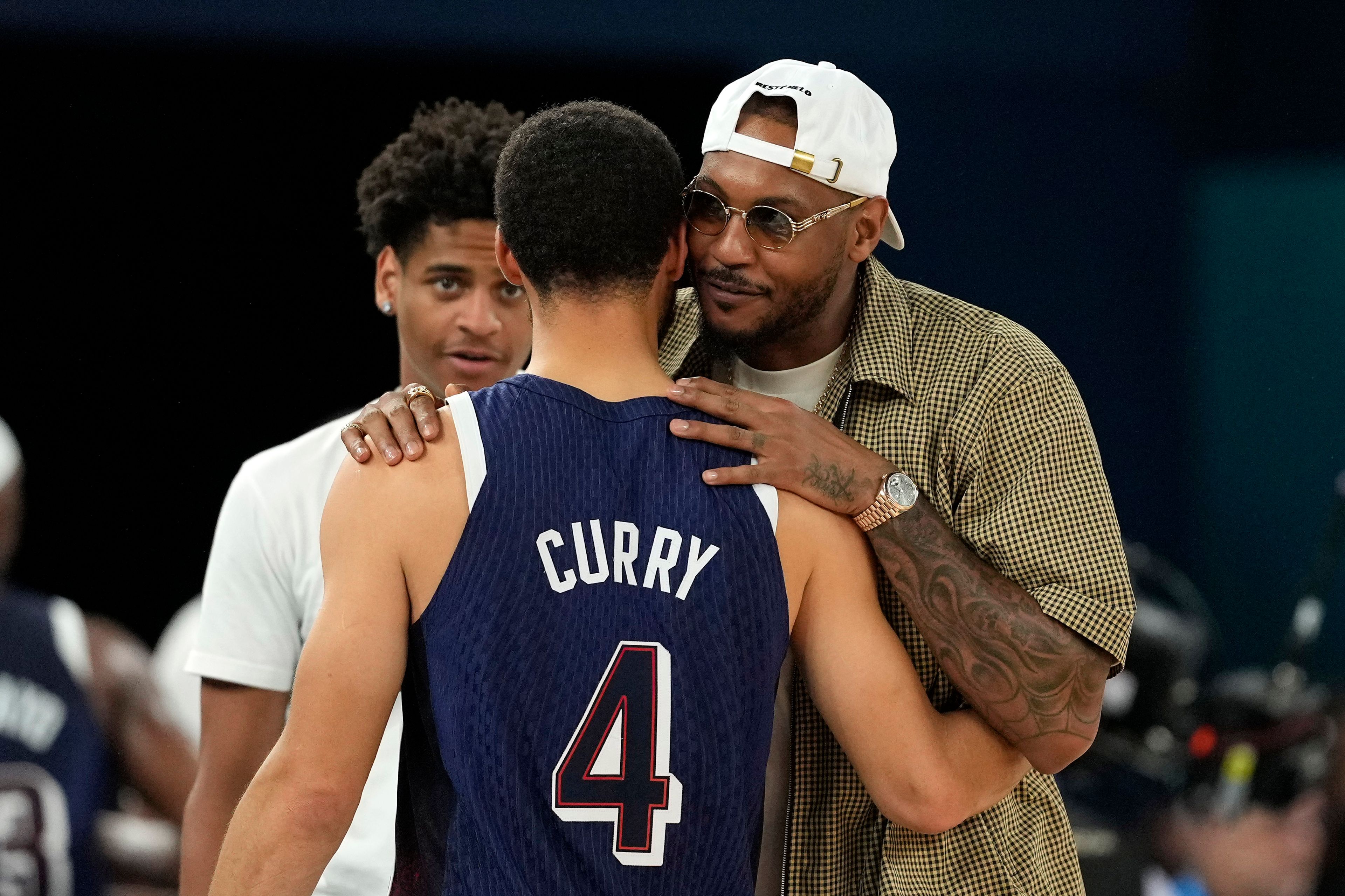 United States' Stephen Curry, center, greets Kiyan Anthony, left, and Carmelo Anthony, after the United States defeated Brazil in a men's basketball game at the 2024 Summer Olympics, Tuesday, Aug. 6, 2024, in Paris, France. (AP Photo/Michael Conroy)