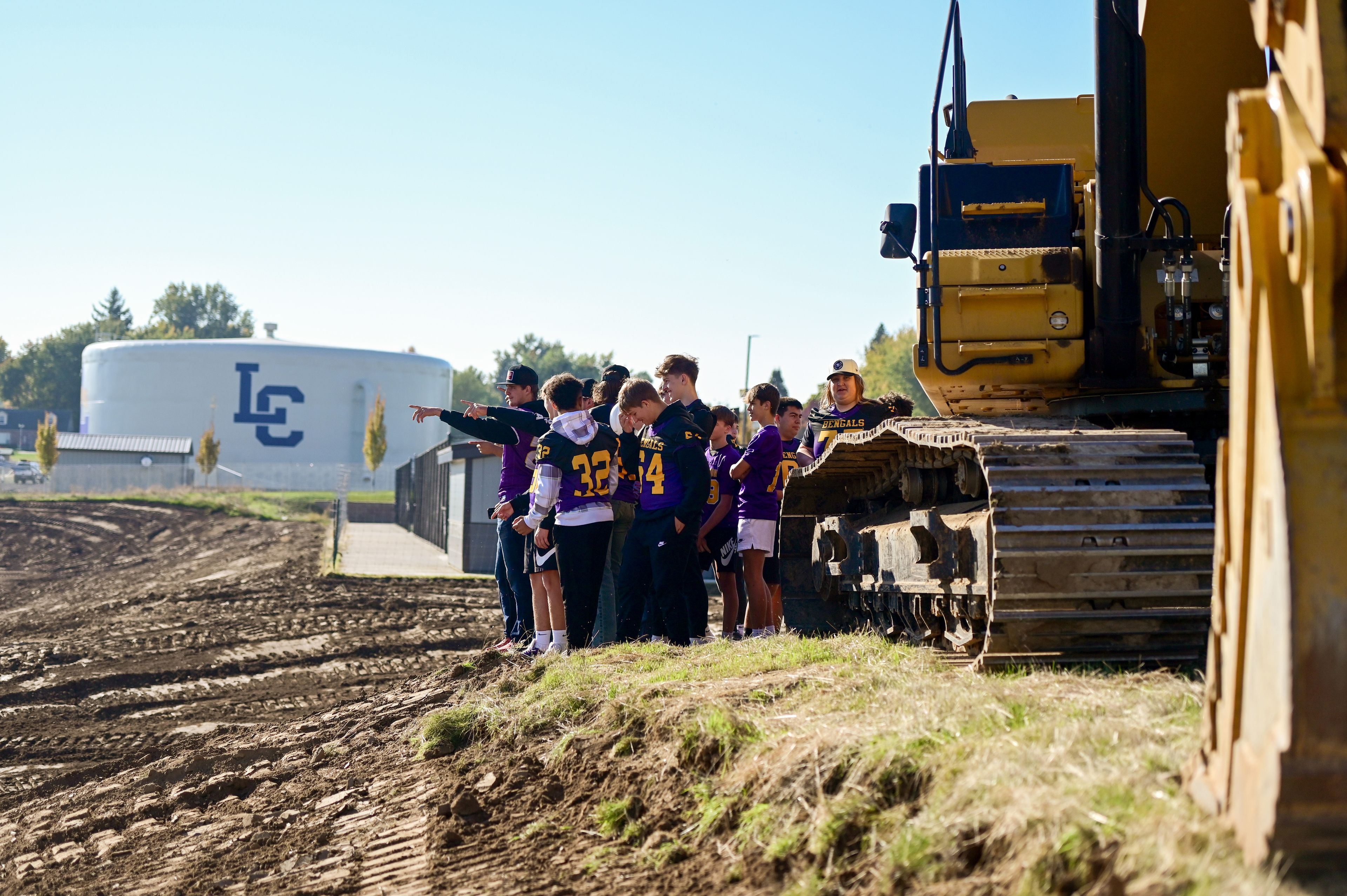 Lewiston High School football players point out at the future local of LHS’s athletic venues after a groundbreaking event for the start of construction on Saturday.