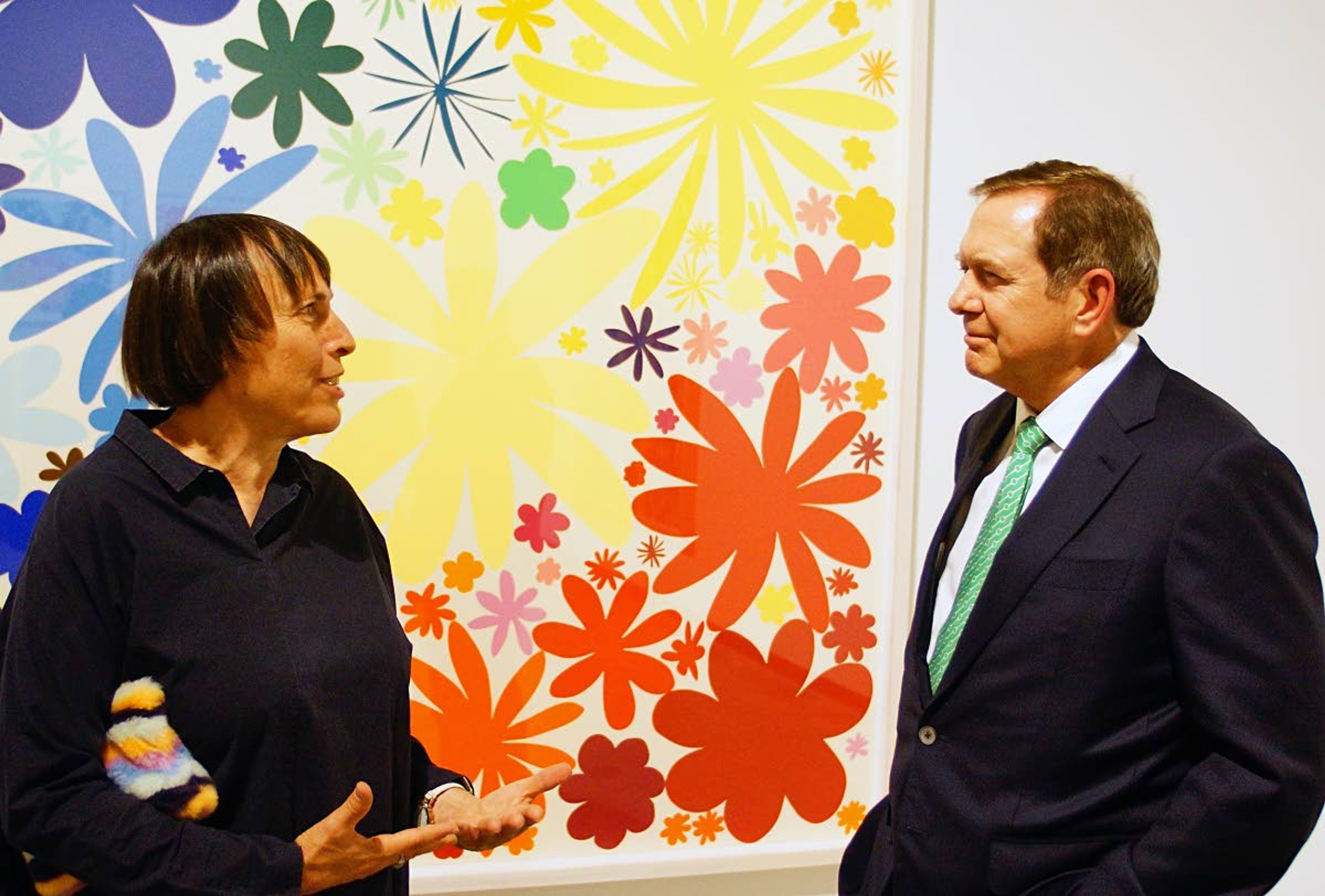 Standing in front of one of her brightly colored prints, Polly Apfelbaum talks with donor Jordan Schnitzer during the opening reception of an exhibit of her work last week in the museum of art bearing Mr. Schnitzer’s name at Washington State University.