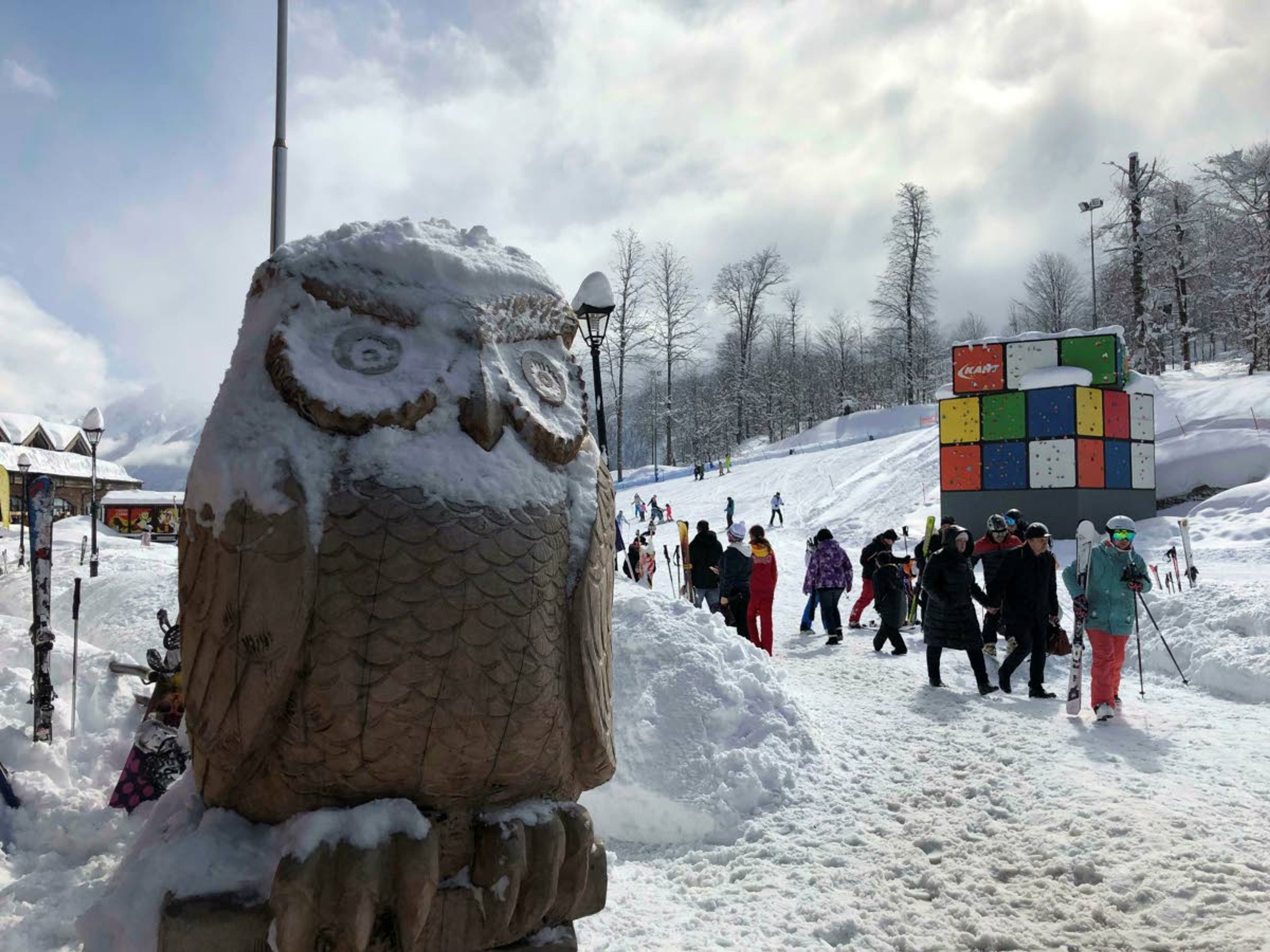 In this photo taken on Sunday, March 3, 2019, tourists walk next to the Olympic rings at the mountain resort of Krasnaya Polyana near the Black Sea resort of Sochi, southern Russia. In the five years since the Sochi Olympics, Russians have been flocking south to enjoy their subtropical ski slopes, with nearly a million visitors making the trip each winter. (AP Photo/James Ellingworth)