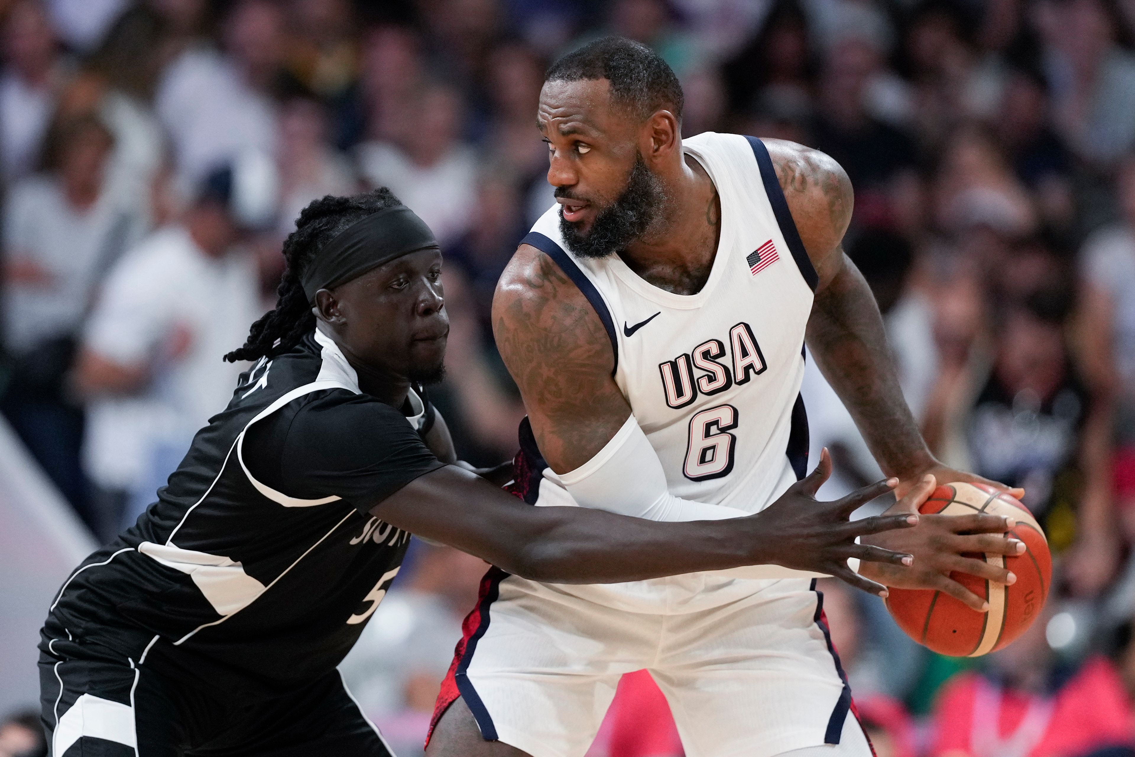 Nuni Omot, of South Sudan, defends LeBron James, of the United States, in a men's basketball game at the 2024 Summer Olympics, Wednesday, July 31, 2024, in Villeneuve-d'Ascq, France. (AP Photo/Mark J. Terrill)