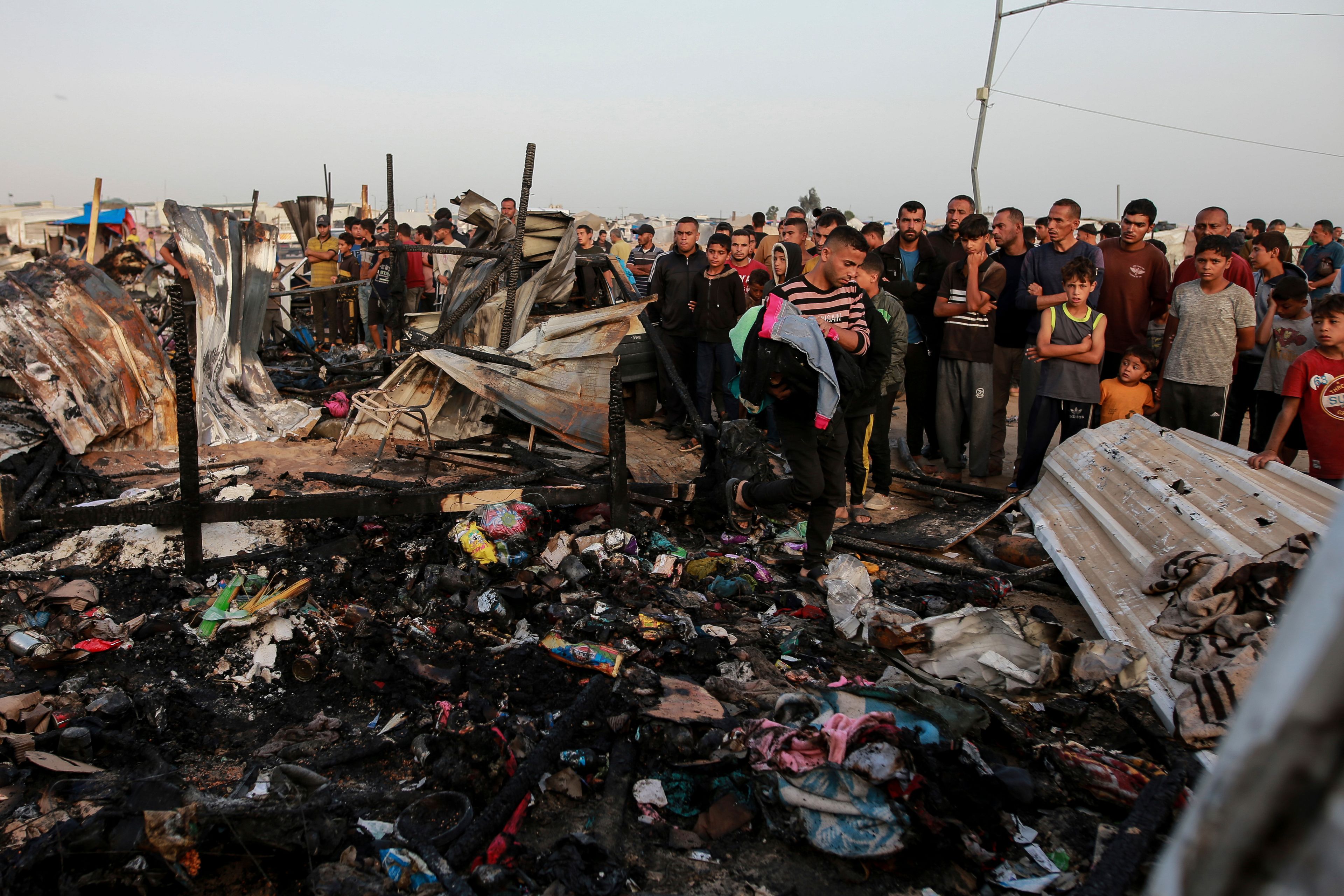 FILE - Palestinians look at the destruction after an Israeli strike where displaced people were staying in Rafah, Gaza Strip, Monday, May 27, 2024. Throughout its grinding seven-month war against Hamas, Israel has pledged to investigate a series of deadly events in which its military forces are suspected of wrongdoing. The commitment comes in the face of mounting claims — from human rights groups and the International Criminal Court's chief prosecutor — that the country's leaders are committing war crimes in Hamas-ruled Gaza.