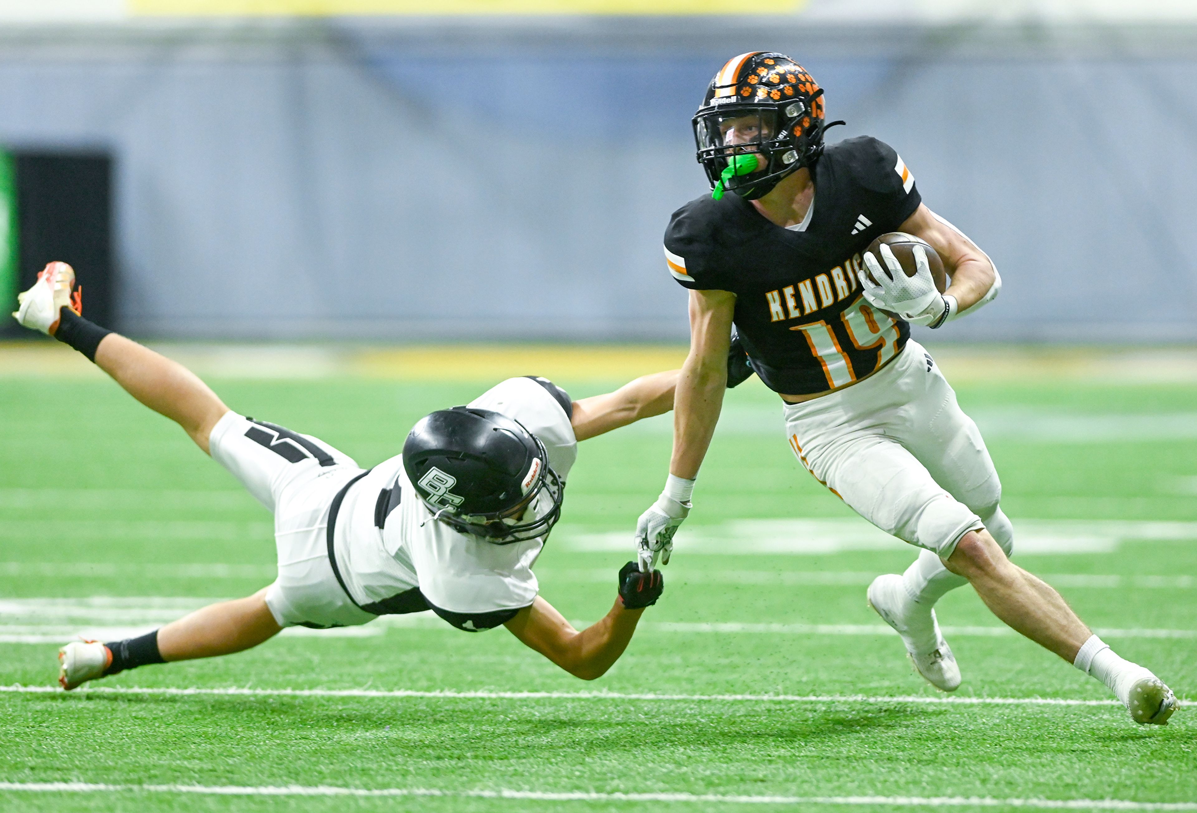 Kendrick’s Sawyer Hewett dodges a tackle attempt by Butte County’s Cooper Williams Friday during the Idaho 2A football state championship game at the P1FCU Kibbie Dome in Moscow.