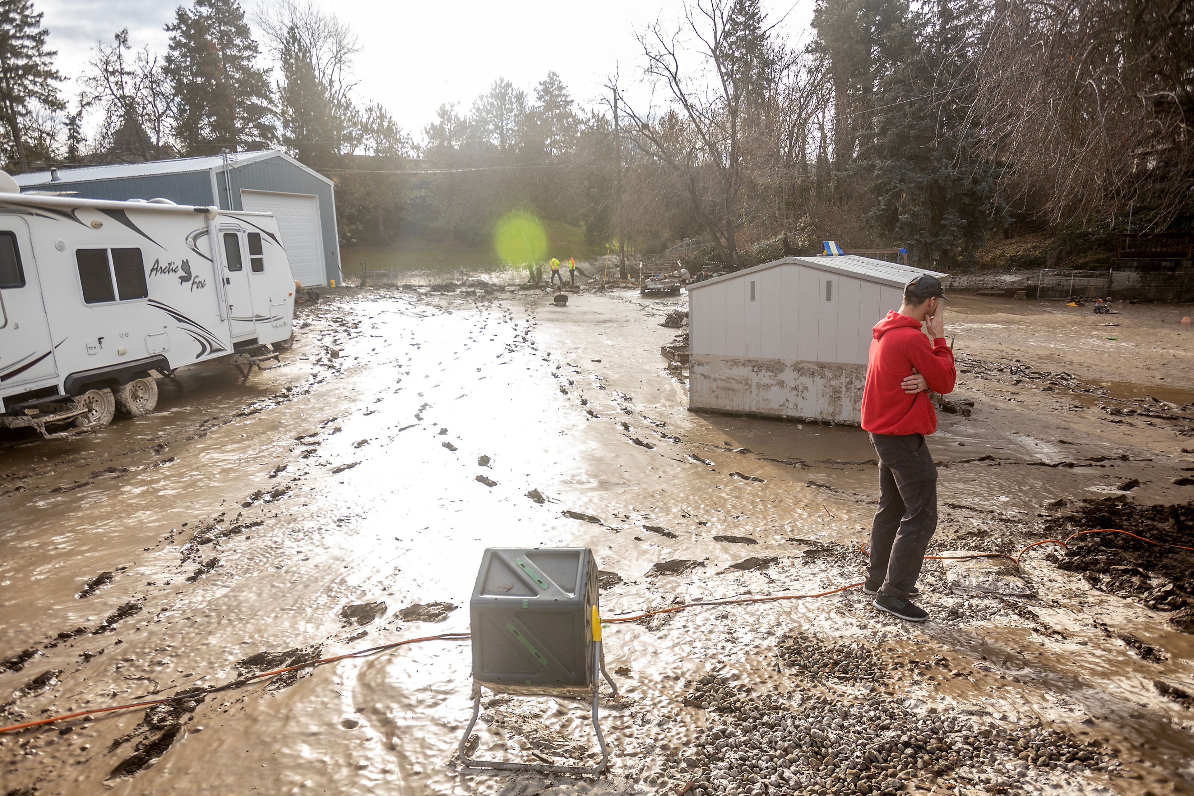 Ramone Royce runs a hand over his face while looking over his mud and debris covered back yard after a water reservoir at the corner of 16th Avenue and 29th Street burst in the early hours of Wednesday morning in Lewiston.