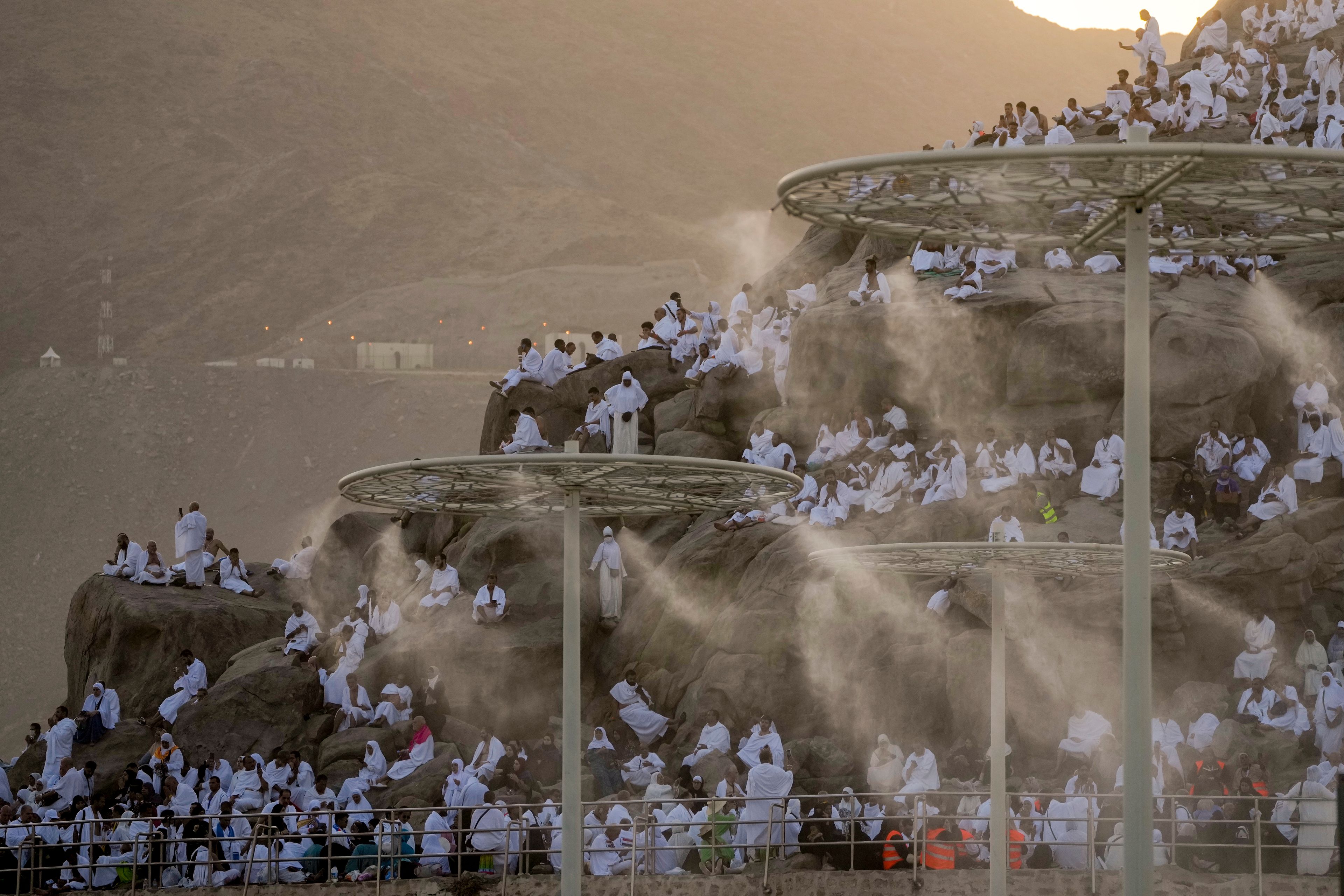 FILE - Water mist is sprayed on Muslim pilgrims as they pray on the rocky hill known as the Mountain of Mercy, on the Plain of Arafat, during the annual Hajj pilgrimage, near the holy city of Mecca, Saudi Arabia, on June 27, 2023.