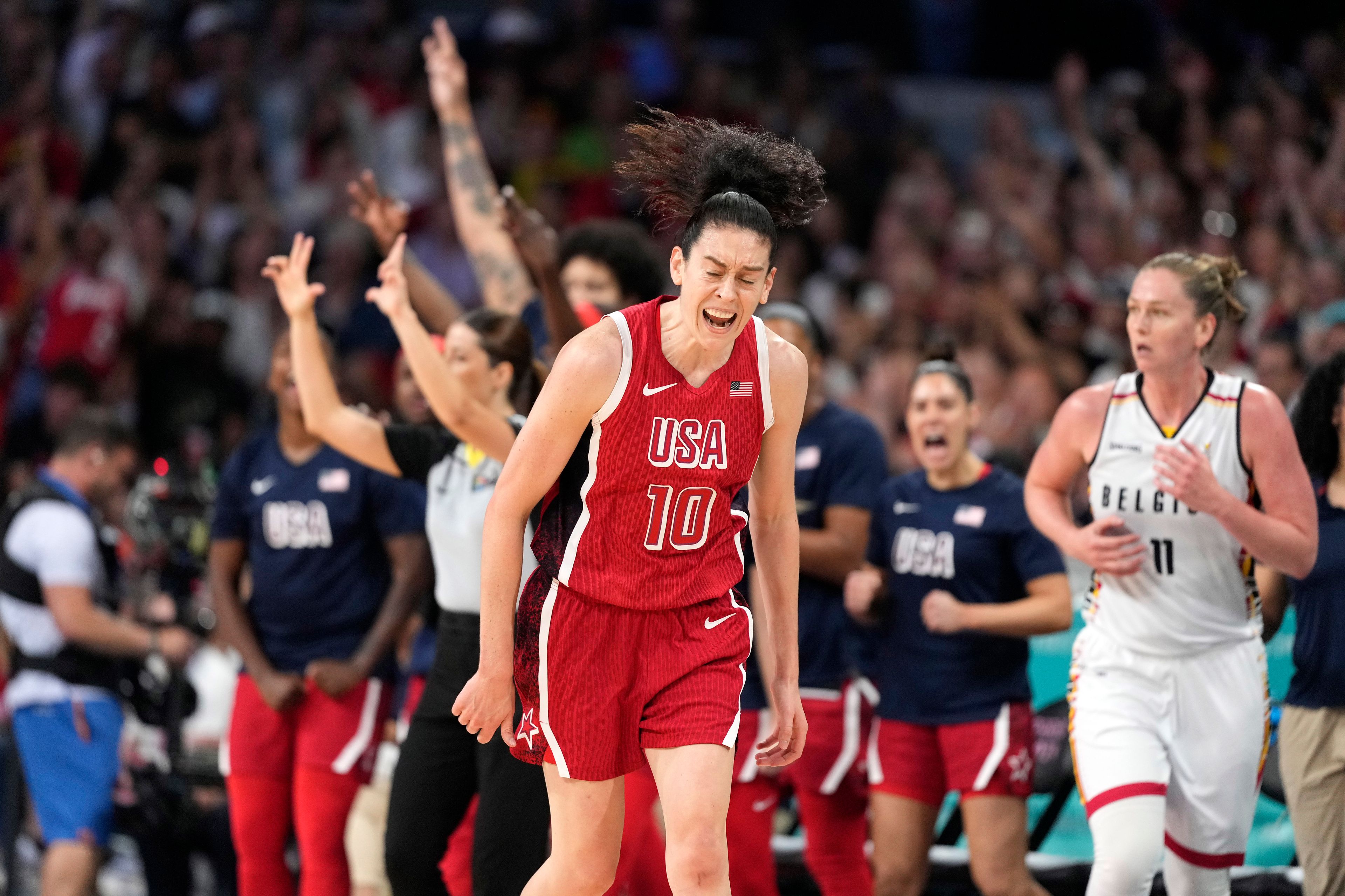 United States' Breanna Stewart, center, celebrates after scoring as Belgium's Emma Meesseman, right, runs along during a women's basketball game at the 2024 Summer Olympics, Thursday, Aug. 1, 2024, in Villeneuve-d'Ascq, France. (AP Photo/Michael Conroy)