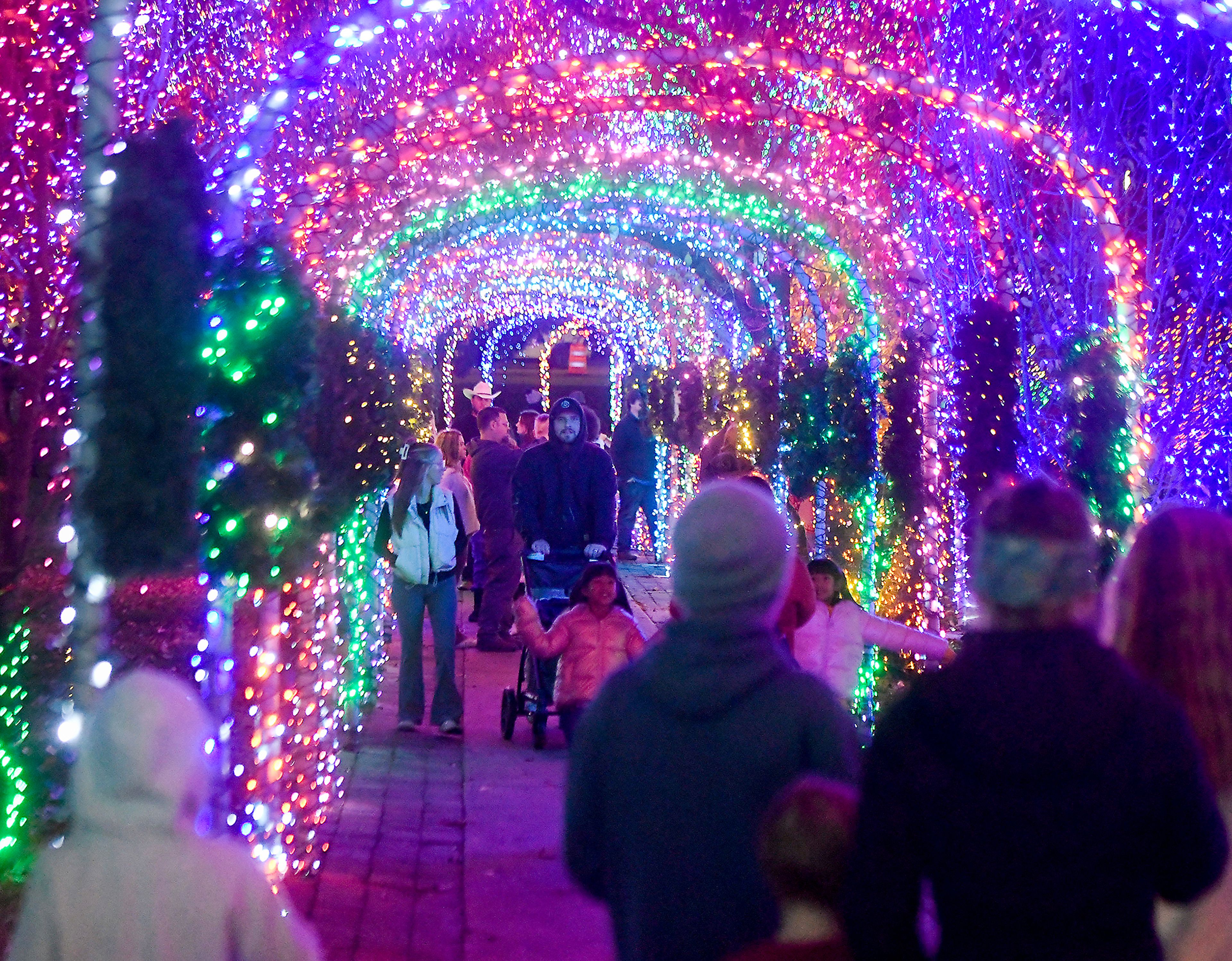 A tunnel of lights shine over people Saturday after the opening of the Winter Spirit holiday display at Locomotive Park in Lewiston.