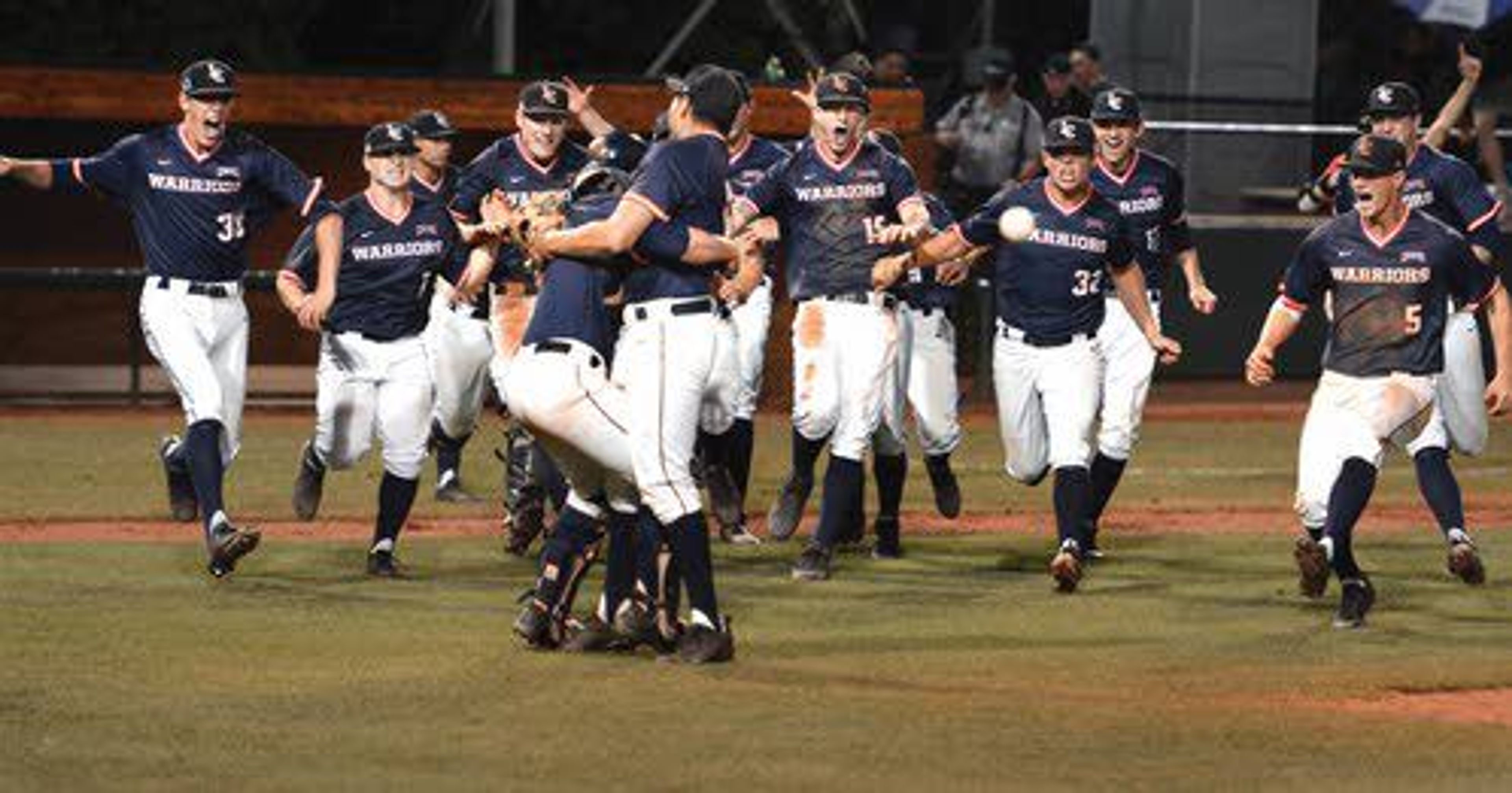 Lewis-Clark State players rush the field as Cooper Goldby bear hugs Anthony Balderas after inducing a ground ball into a double play to win the NAIA National title Friday at Harris Field.