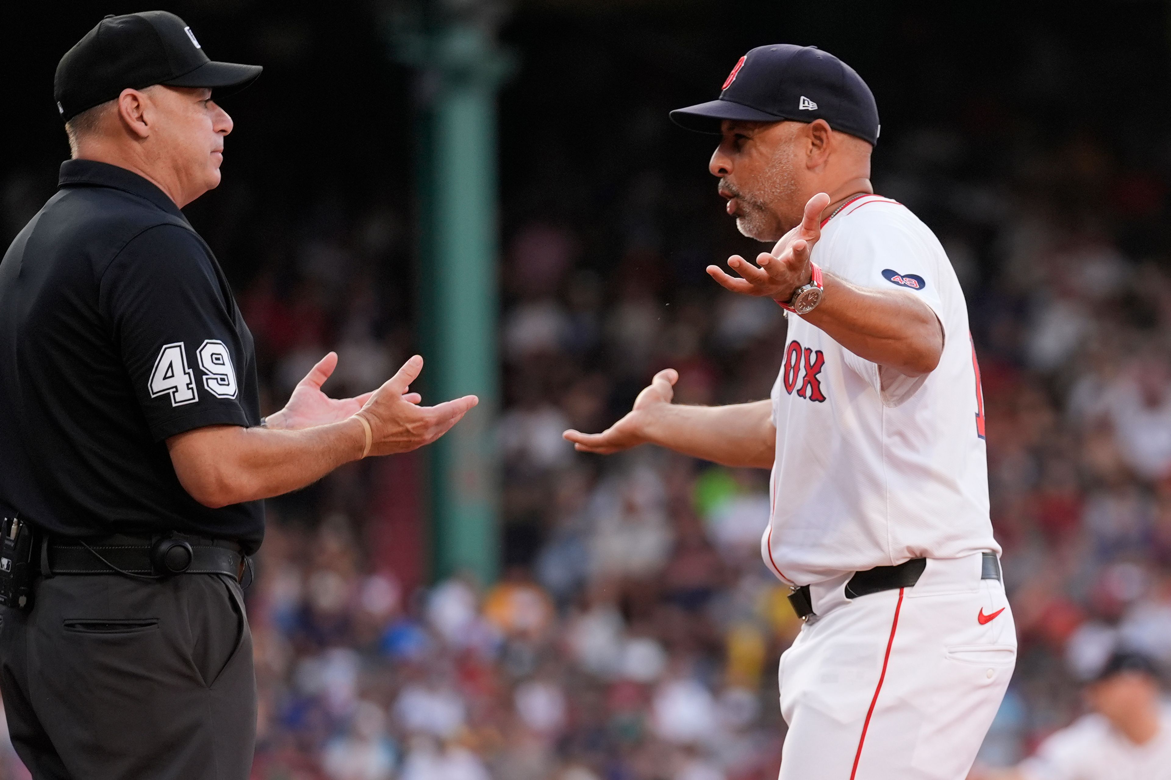 Boston Red Sox manager Alex Cora, right, argues a call with umpire Andy Fletcher (49) during the seventh inning of a baseball game against the Seattle Mariners, Wednesday, July 31, 2024, in Boston. (AP Photo/Charles Krupa)