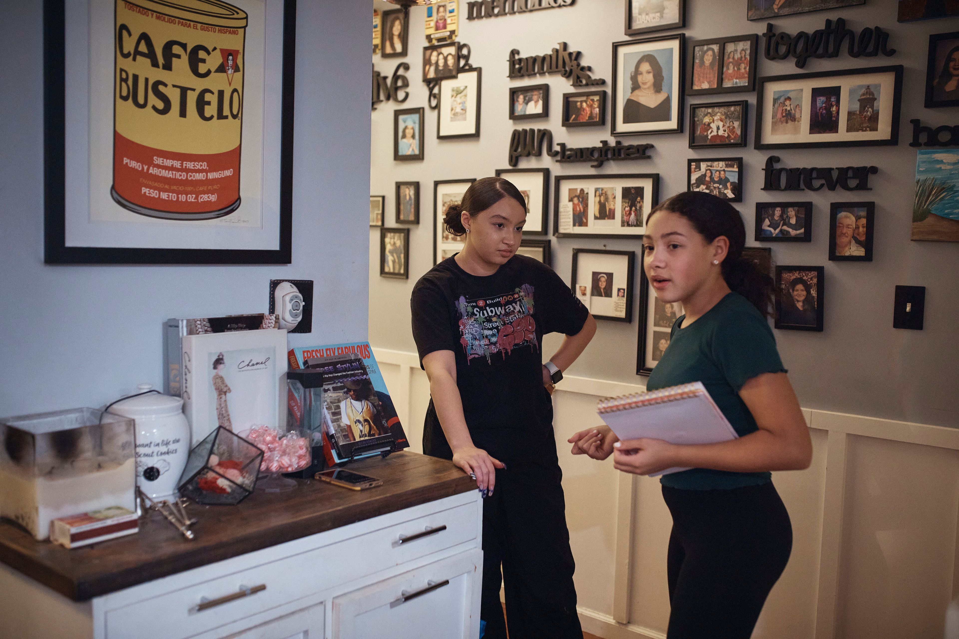 Grace Durham, 11, right, talks with her 17-year-old sister Gabriela, in a hallway of their apartment, Saturday, Jan. 27, 2024, in New York. It is hard to be a teenager today without social media. For those trying to stay off social platforms at a time when most of their peers are immersed, the path can be challenging, isolating and at times liberating. It can also be life-changing.