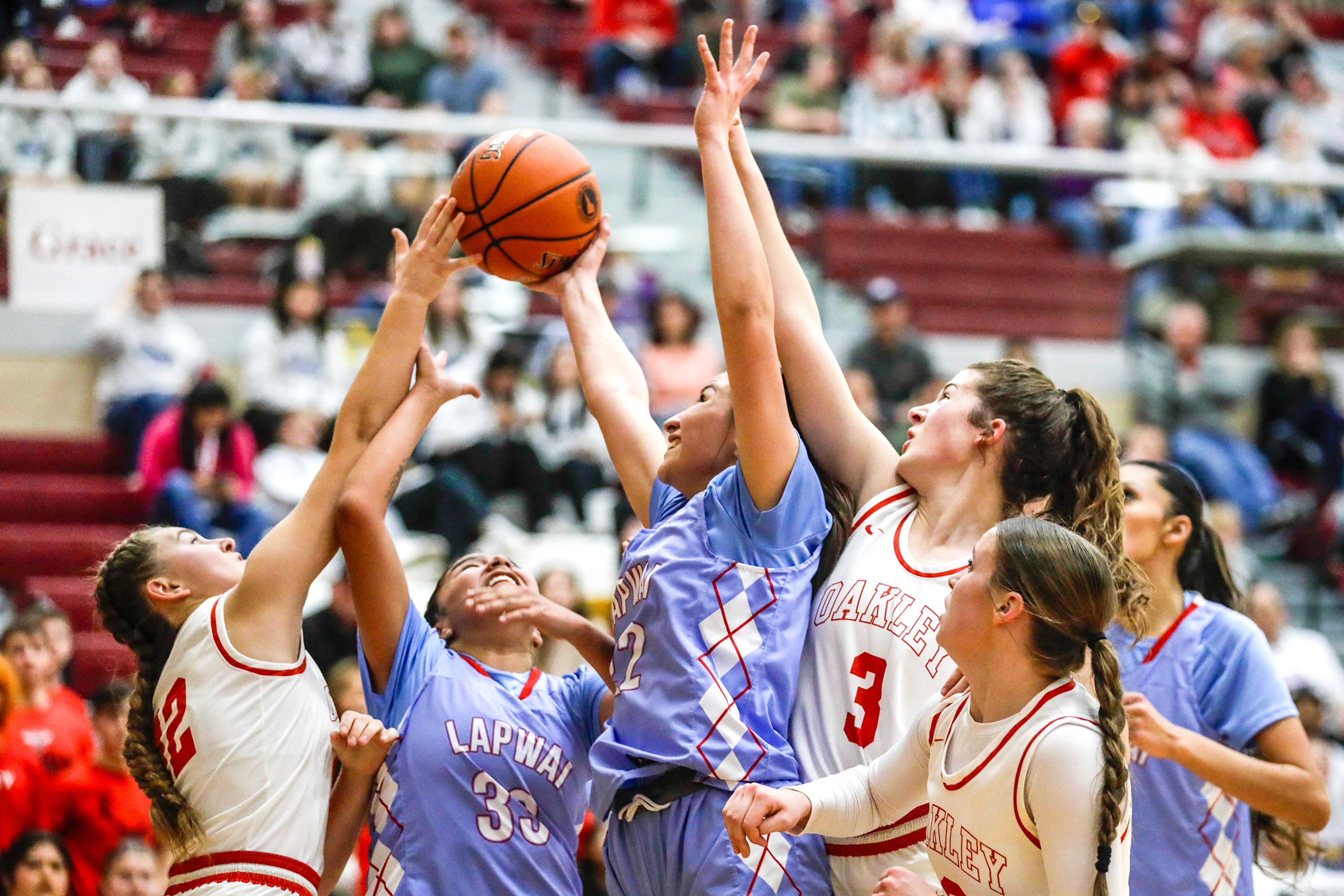 Lapwai's Madden Bisbee and Lapwai's Taya Yearout compete for a rebound with Oakley guard Taylin Beck, left, and Oakley forward Chloe Berlin during an Idaho Class 1A DI girls state semifinal game Friday at Columbia High School.