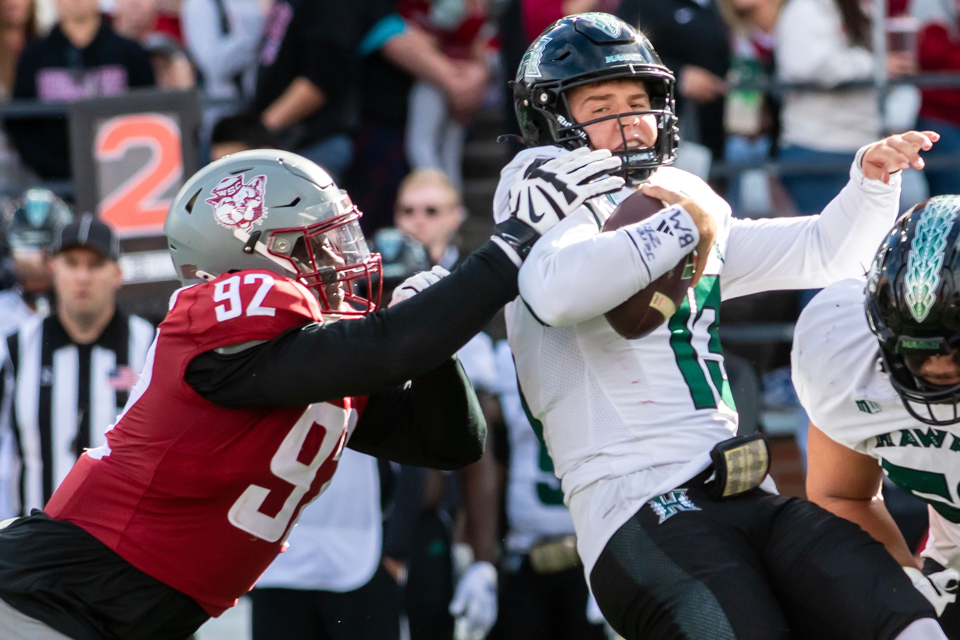 Washington State defensive lineman Ansel Din-Mbuh grabs Hawaii quarterback Brayden Schager as he�s sacked in a college football game on Saturday at Gesa Field in Pullman.,