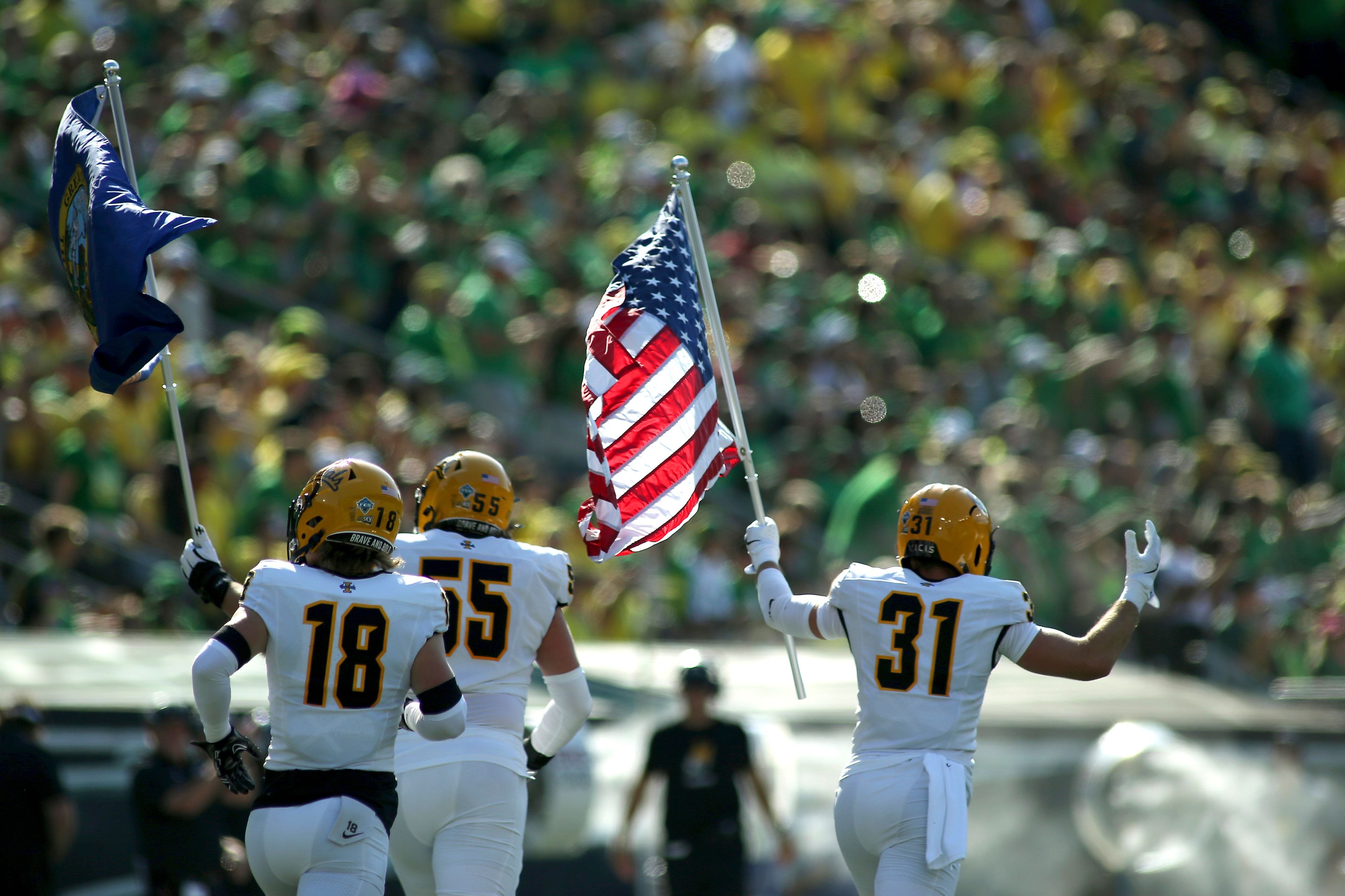 Idaho defensive back Tommy McCormick (18), offensive lineman Jack Foster (55) and linebacker Mathias Bertram (31) run onto the field before an NCAA college football game against Oregon, Saturday, Aug. 31, 2024, in Eugene, Ore. (AP Photo/Lydia Ely)