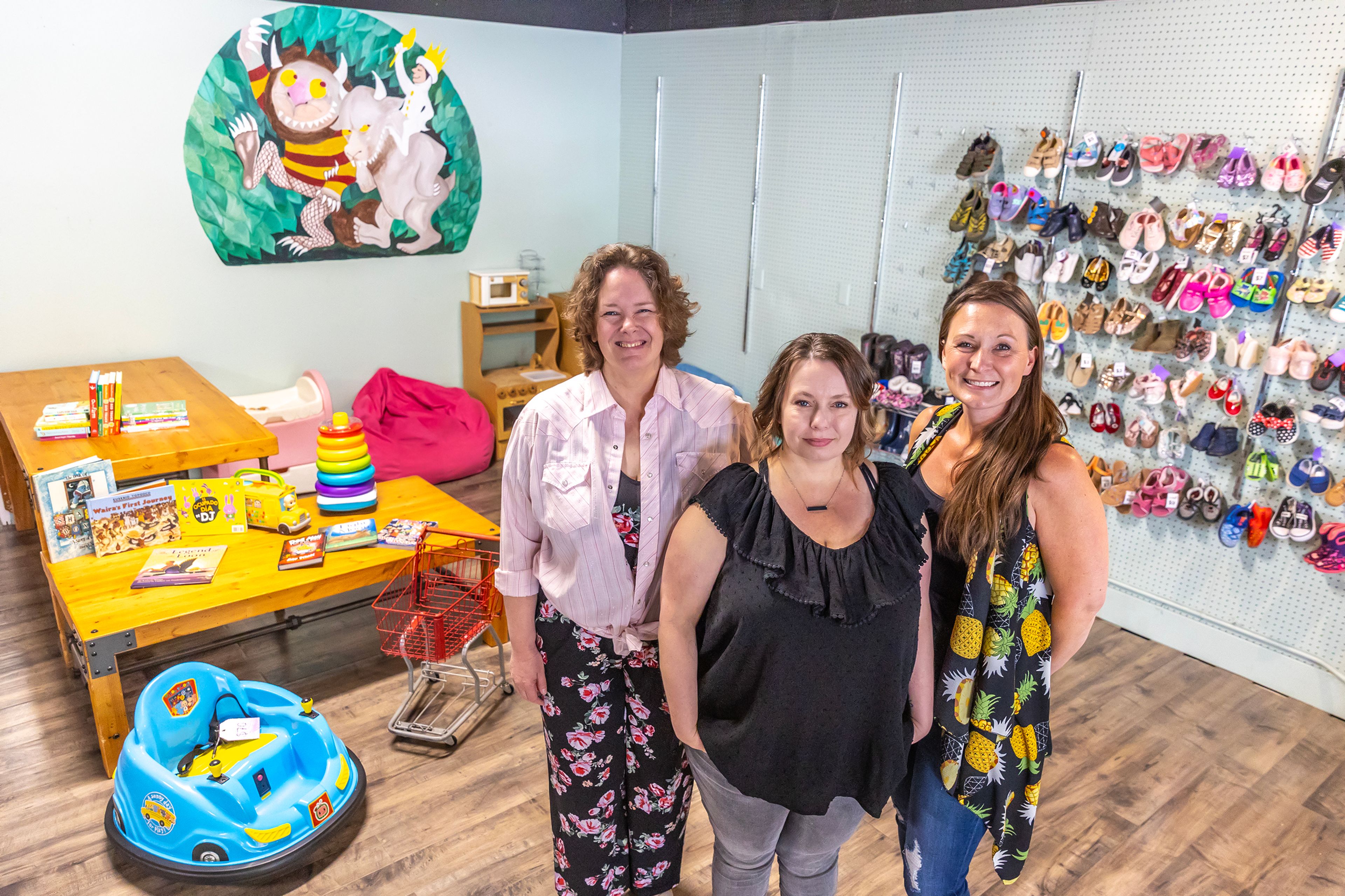 Nicole Moss, from left, Bethany Peterson and Nola Cullum stand in front of a kid’s play area at Bee’s Knees Resale Thursday in Lewiston.