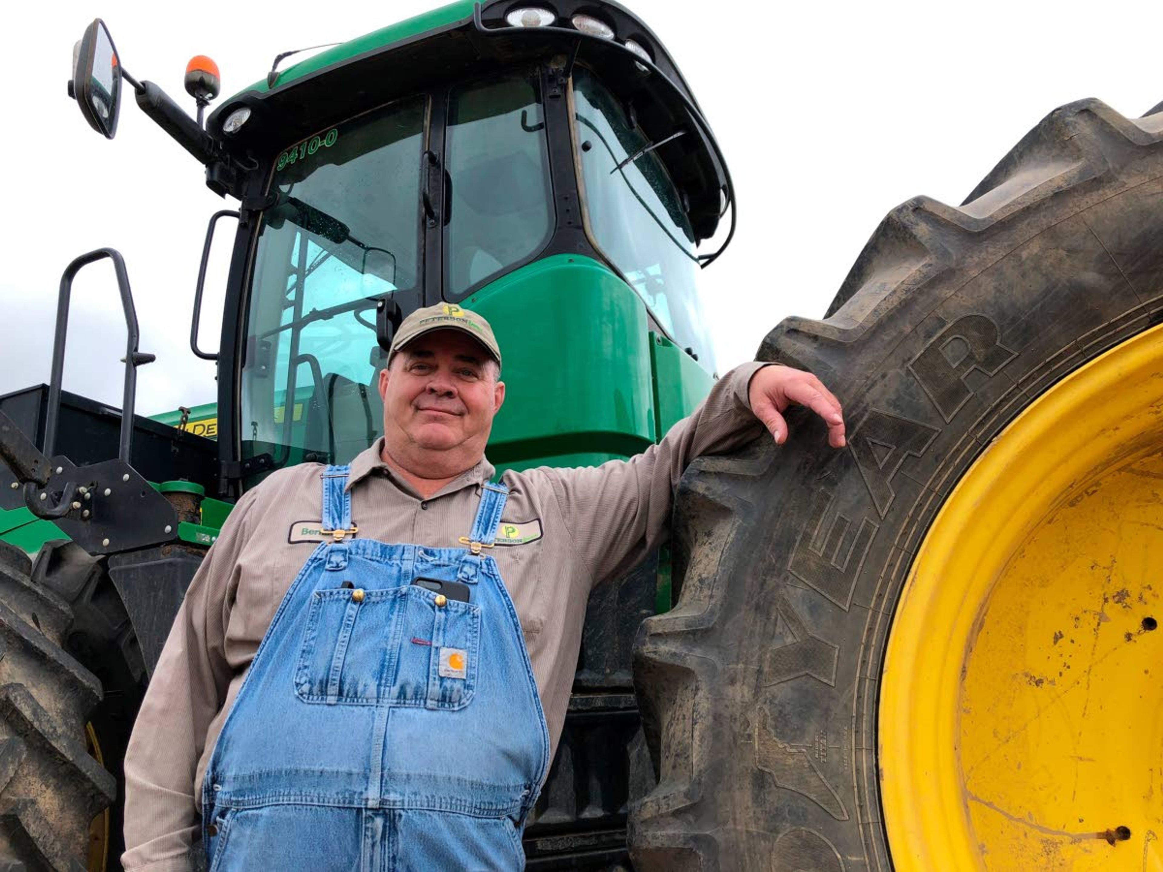 ADVANCE FOR USE WEDNESDAY, JULY 3, 2019, AT 3:01 A.M. EDT AND THEREAFTER - In this Thursday, June 20, 2019, photo, farmer Bernard Peterson leans on a tractor at his farm in Loretto, Ky. When the Trump administration announced a $12 billion aid package for farmers struggling under the financial strain of his trade dispute with China, the payments were capped. But records obtained by The Associated Press under the Freedom of Information Act show that many large farming operations easily found legal ways around the limits to collect big checks. At Peterson's farm, eight members of the family partnership collected a total $863,560 for crops they grow on over 15,000 acres in seven counties, including wheat and corn used at the nearby Maker's Mark bourbon distillery. Peterson said that it didn't make up for all their losses at a time when it was already hard to be profitable. The $1.65 per bushel aid payments for soybeans fell well short of losses he estimated at $2 to $2.50 per bushel, factoring in the loss of the Chinese market that took years to develop. (AP Photo/Dylan Lovan)