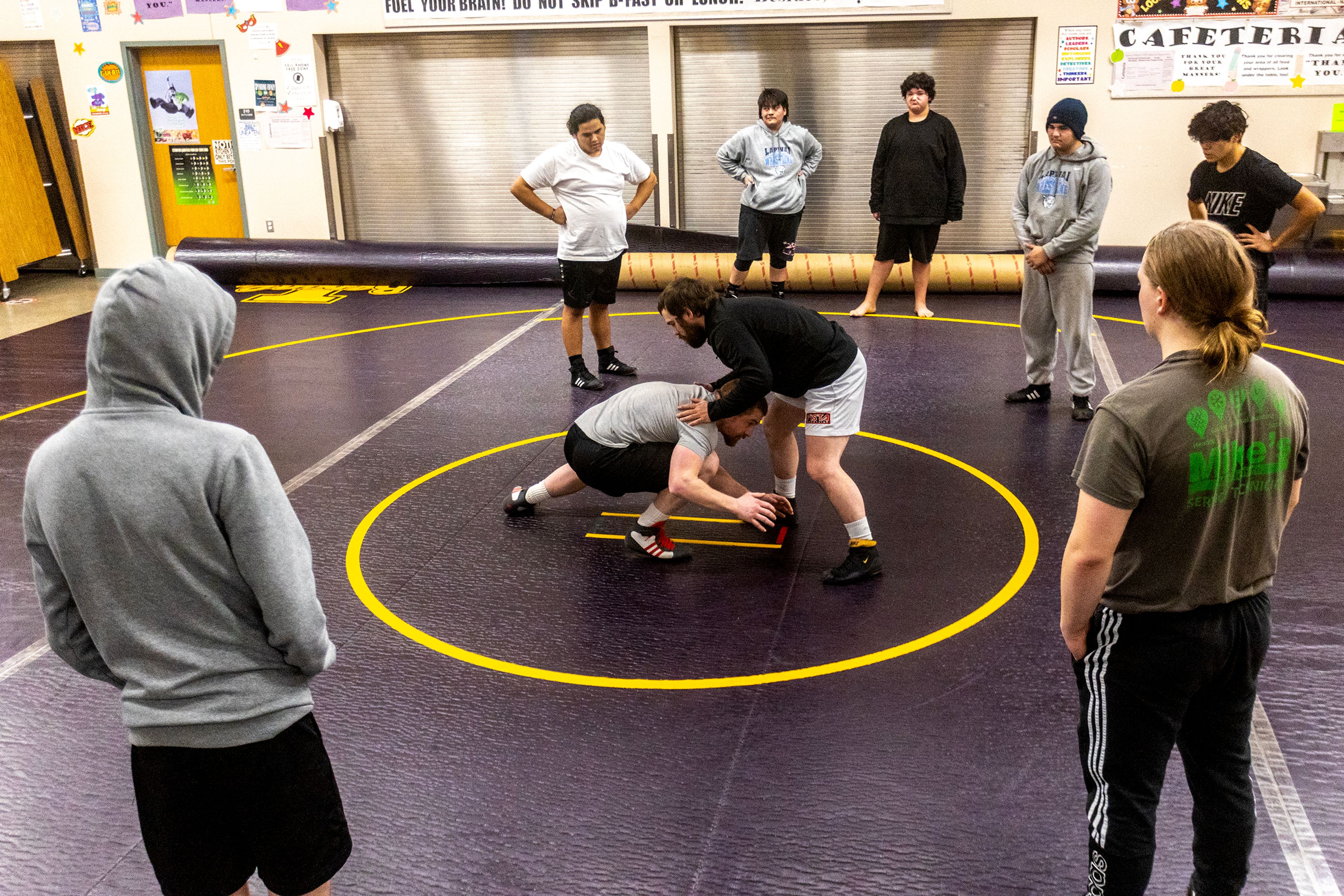 Lapwai wrestling coaches Matt Lattuada, left, and Chris Katus demonstrate takedowns during a Jan. 11 practice.