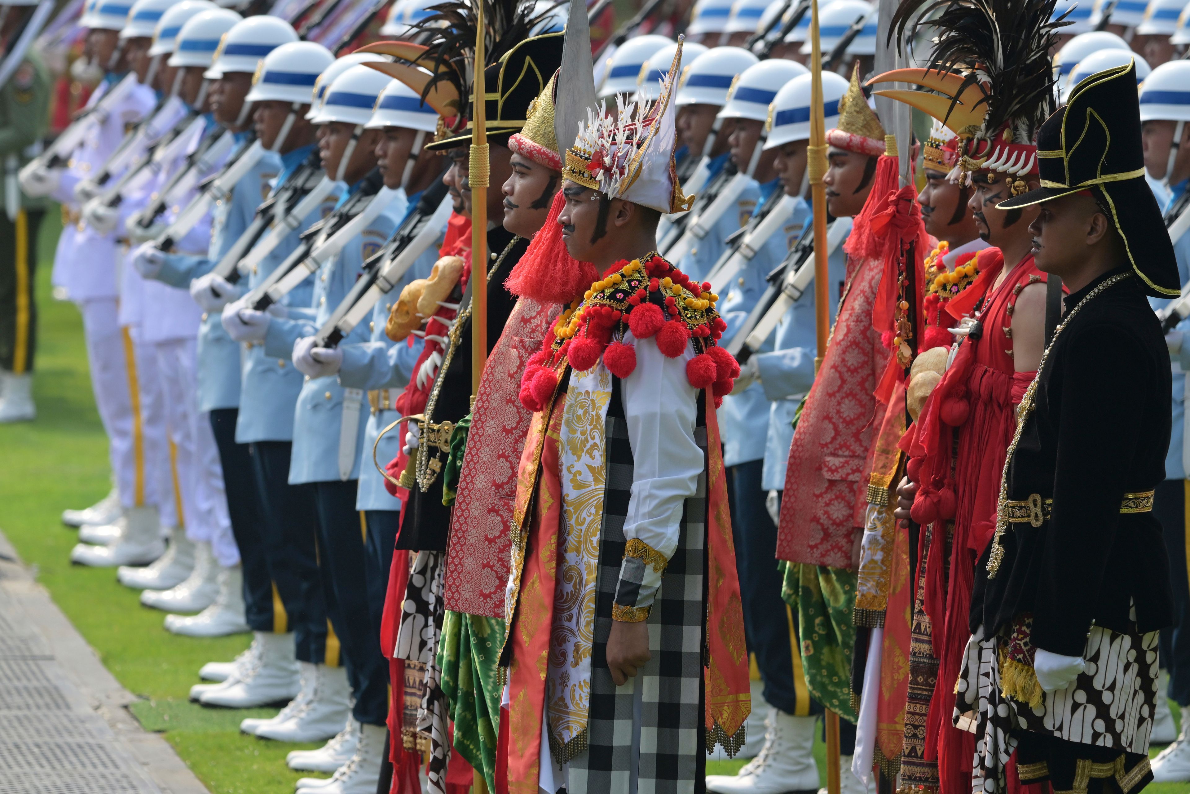 Participants in traditional attire and uniformed personnel stand in formation ahead of the ceremonial welcome for Pope Francis at the Presidential Palace in Jakarta Wednesday, Sept. 4, 2024.