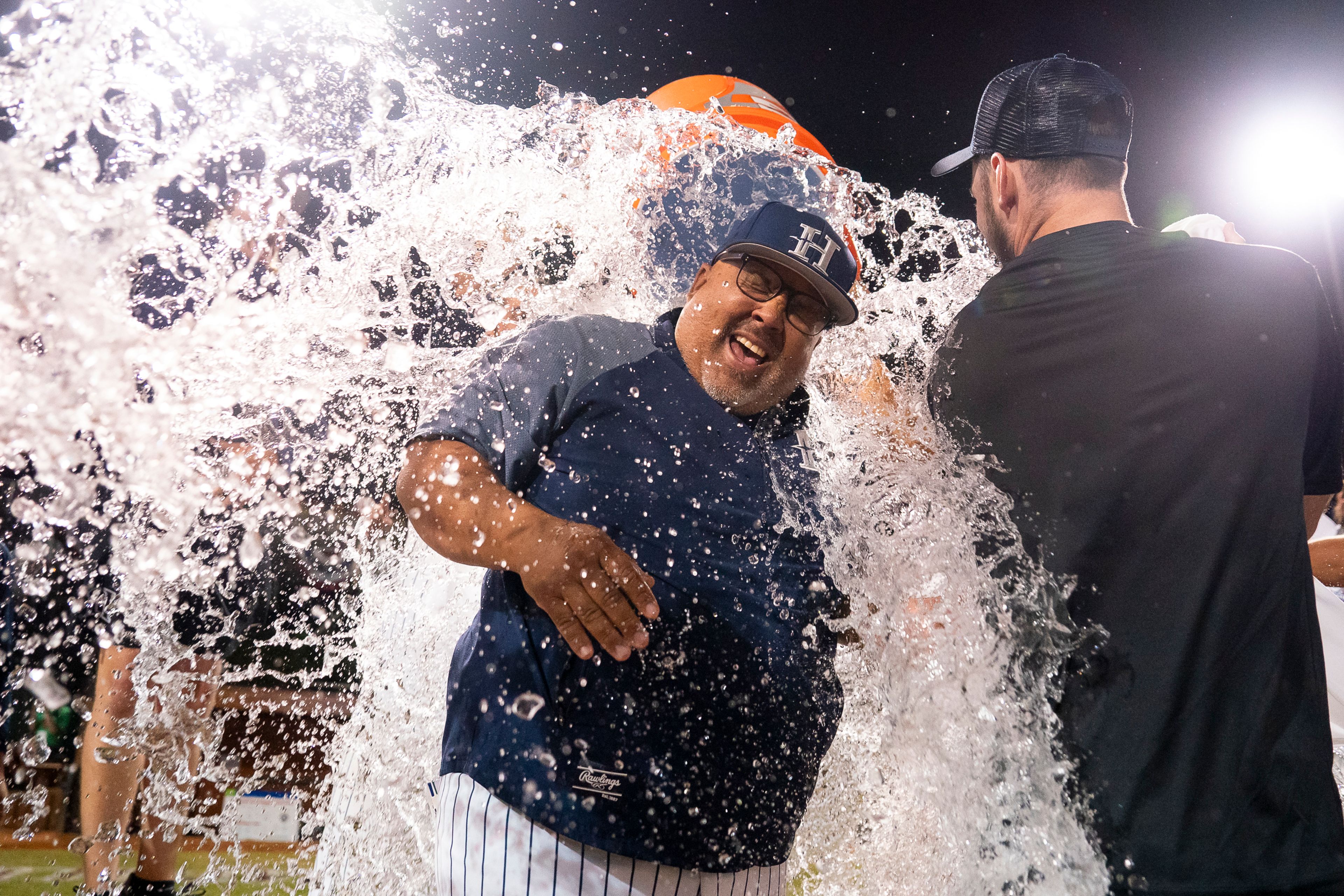 Hope International head coach Larry Mahoney has Gatorade dumped on him after winning Game 19 of the NAIA World Series against Tennessee Wesleyan on Friday at Harris Field in Lewiston.