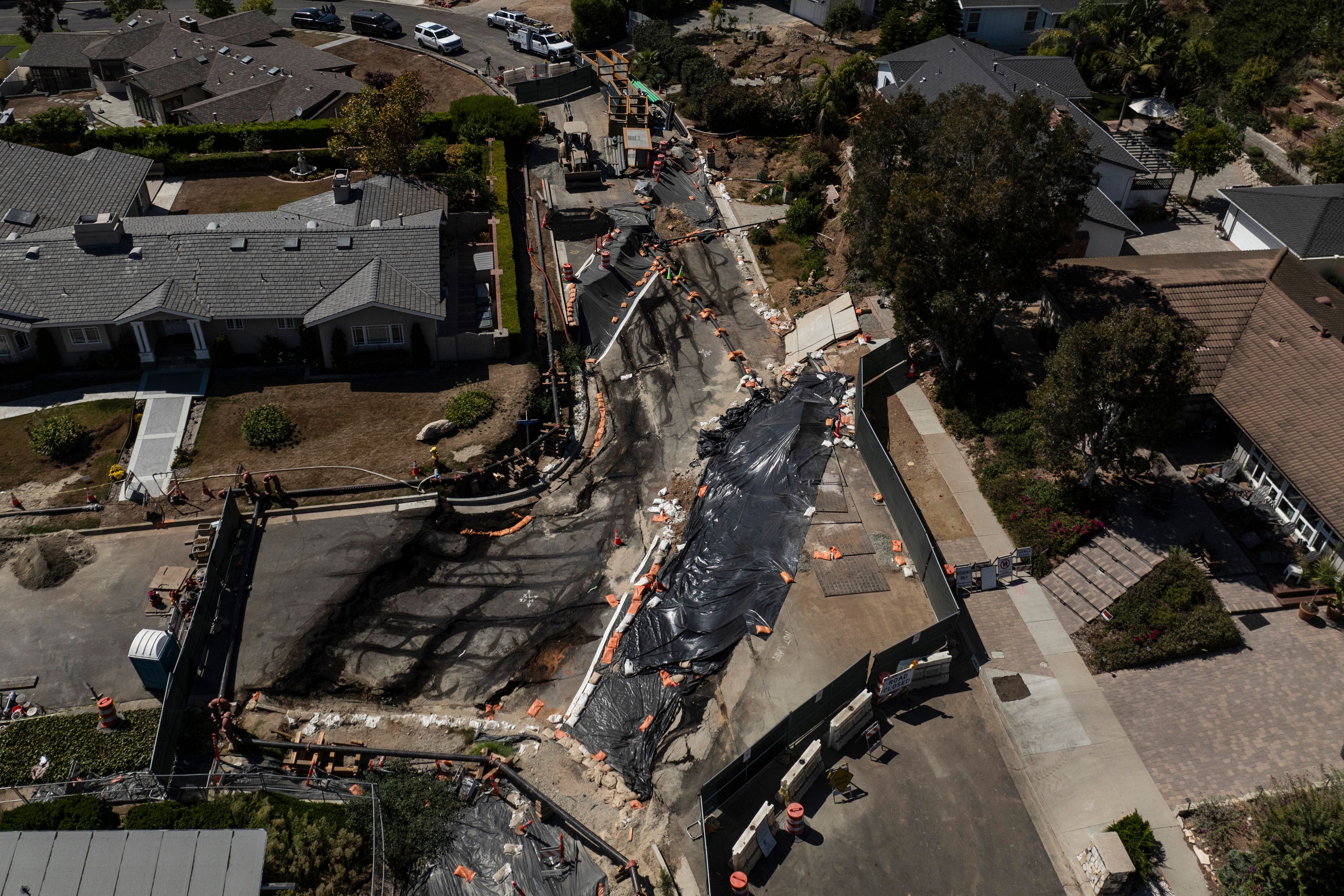 Collapsed roads are covered with tarps in a neighborhood damaged by ongoing landslides in Rancho Palos Verdes, Calif., Tuesday, Sept. 3, 2024.