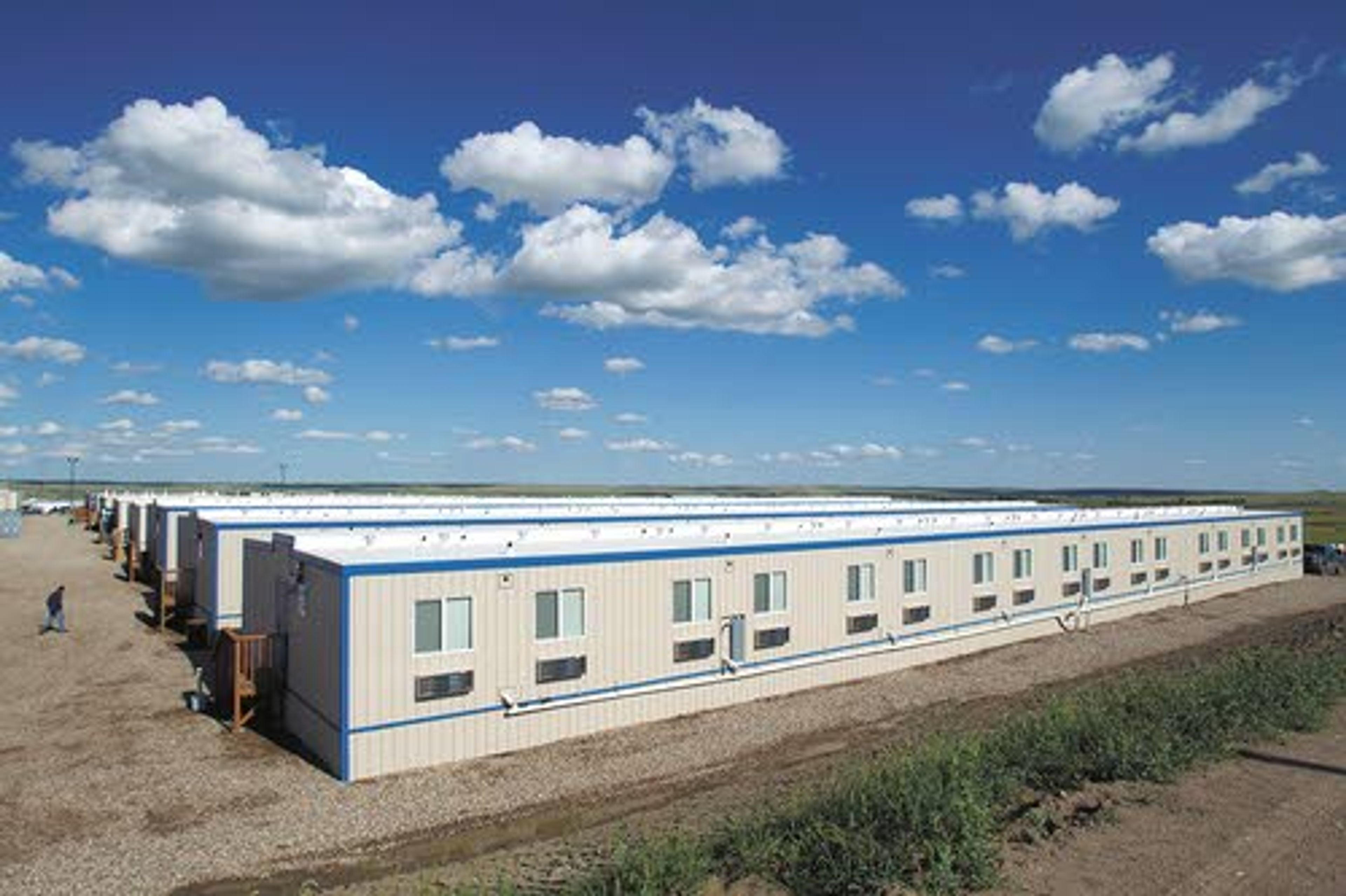 A man walks back to his temporary housing unit outside of
Williston, N.D.