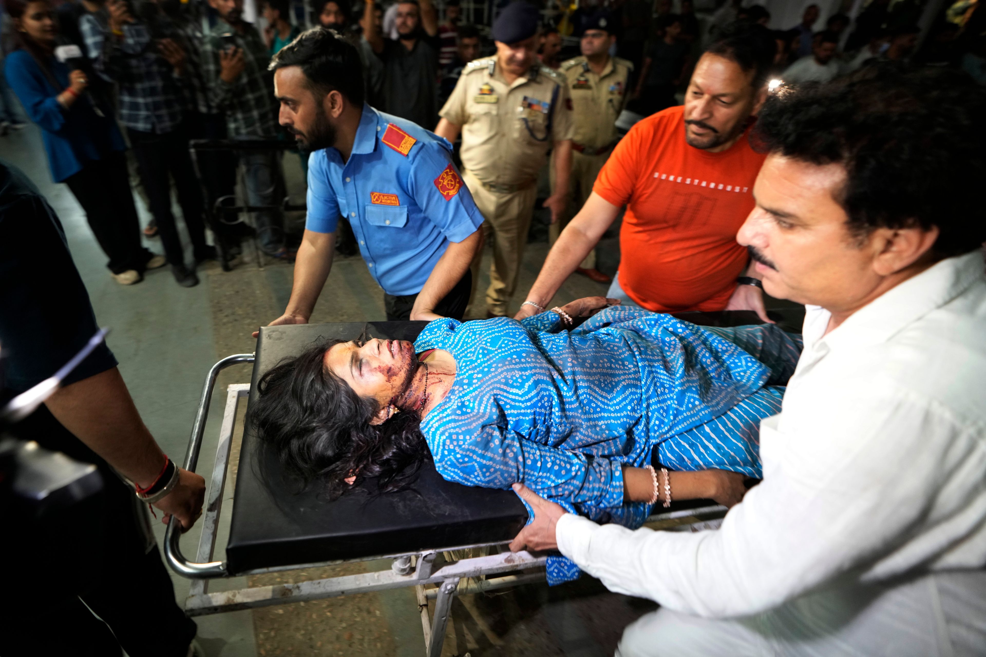 An injured woman is brought to the Government Medical College Hospital in Jammu after the bus she was traveling in fell into a deep gorge in the Pouni area of Jammu's Reasi district, India, Sunday, June 9, 2024. Officials in Indian-controlled Kashmir say at least nine people have been killed after suspected militants fired at a bus with Hindu pilgrims, which then fell into a deep gorge.