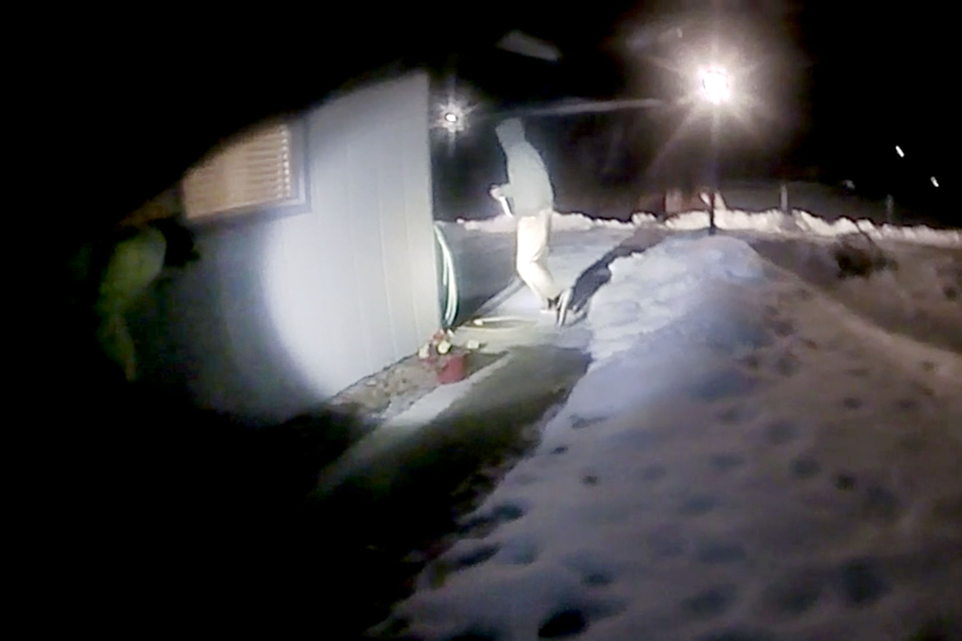 Michael J. Trappett goes around a corner of his parents’ house while carrying a knife in this image taken from an officer’s body camera footage. Moments after this image, Trappett was shot and killed by the officers after turning toward them with the knife held up in his right hand.