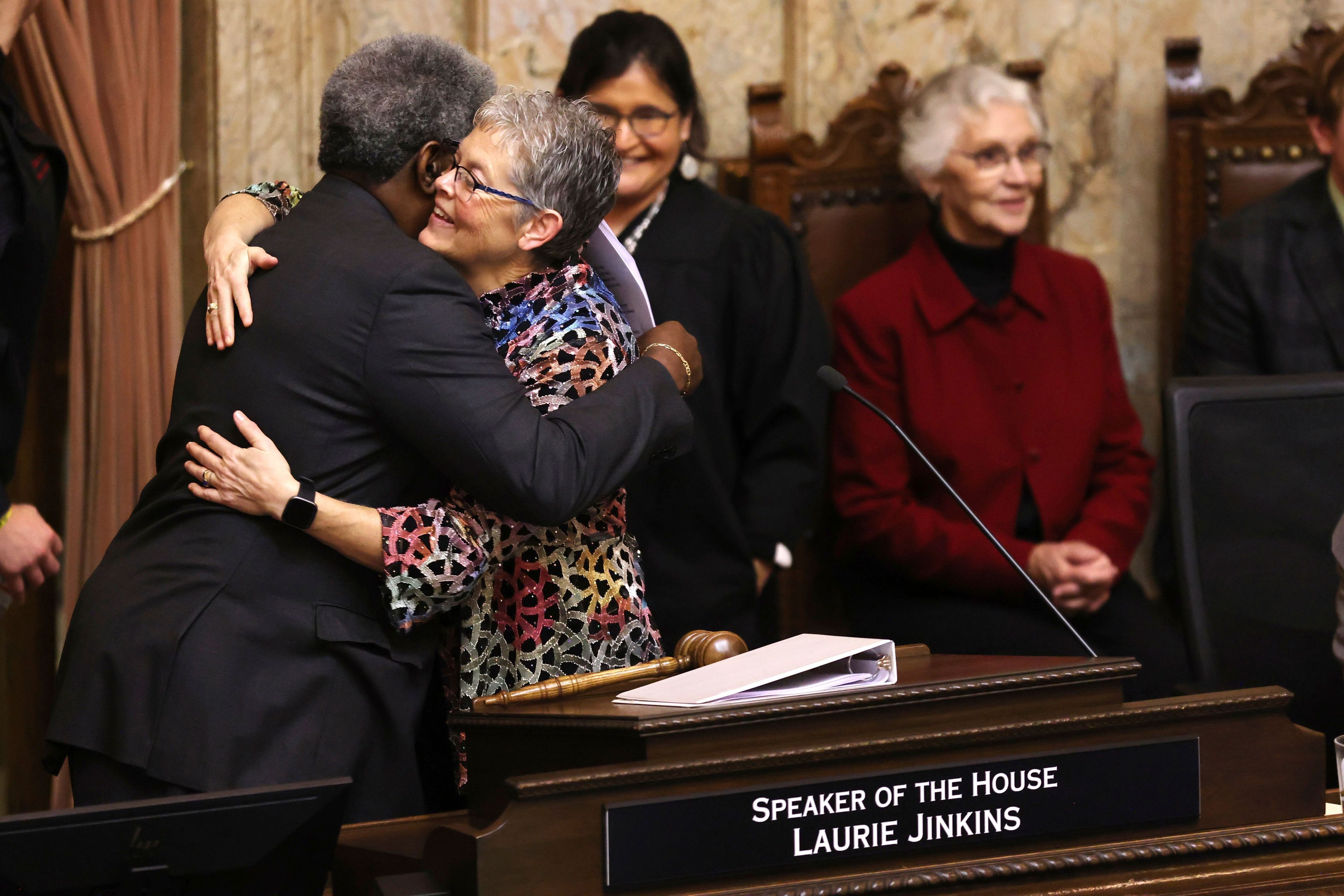 Speaker of the House Laurie Jinkins hugs Pastor Gregory Christopher from the Shiloh Baptist Church in Tacoma on the first day of the legislative session at the Washington state Capitol in Olympia, Wash., on Monday, Jan. 9, 2023. (Karen Ducey/The Seattle Times via AP)