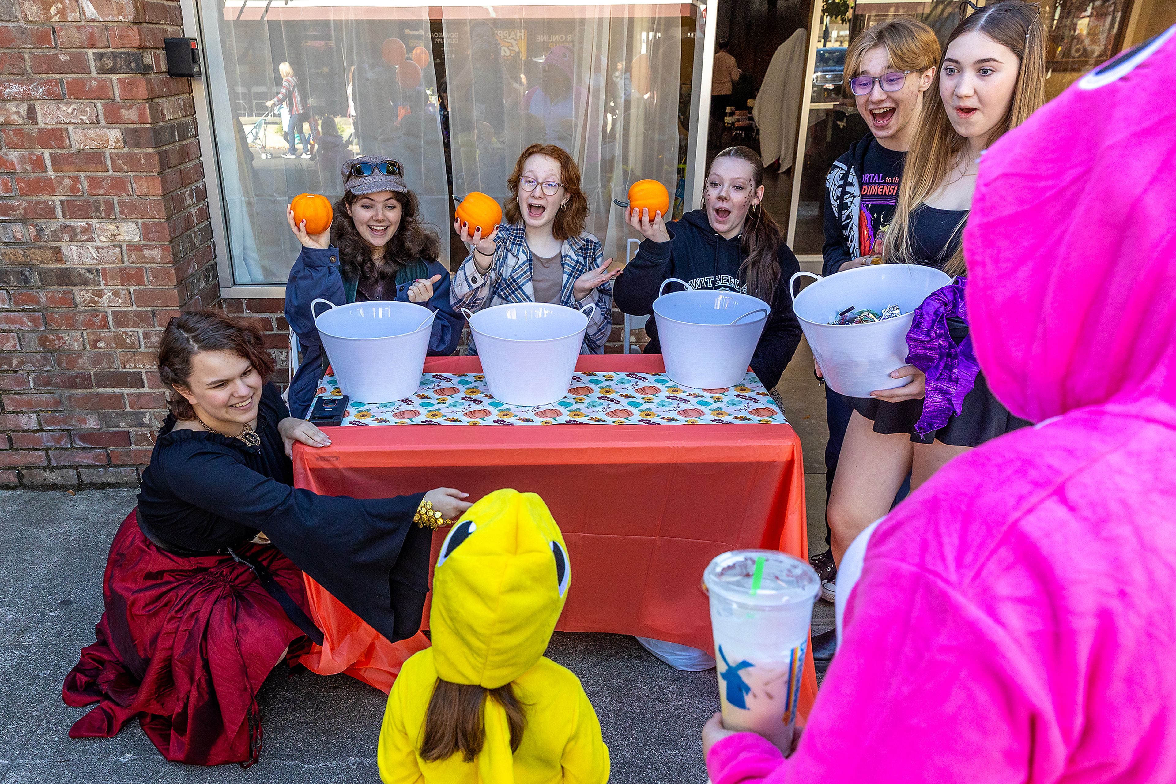 Lewiston High School Drama president Anikka Wilponen, from left, Jenna Clift, vice president, Lauren Gibbs, and Hannah Wilson react as a contestant matches three pumpkins at their human lottery booth Saturday at Pumpkin Palooza in downtown Lewiston.,