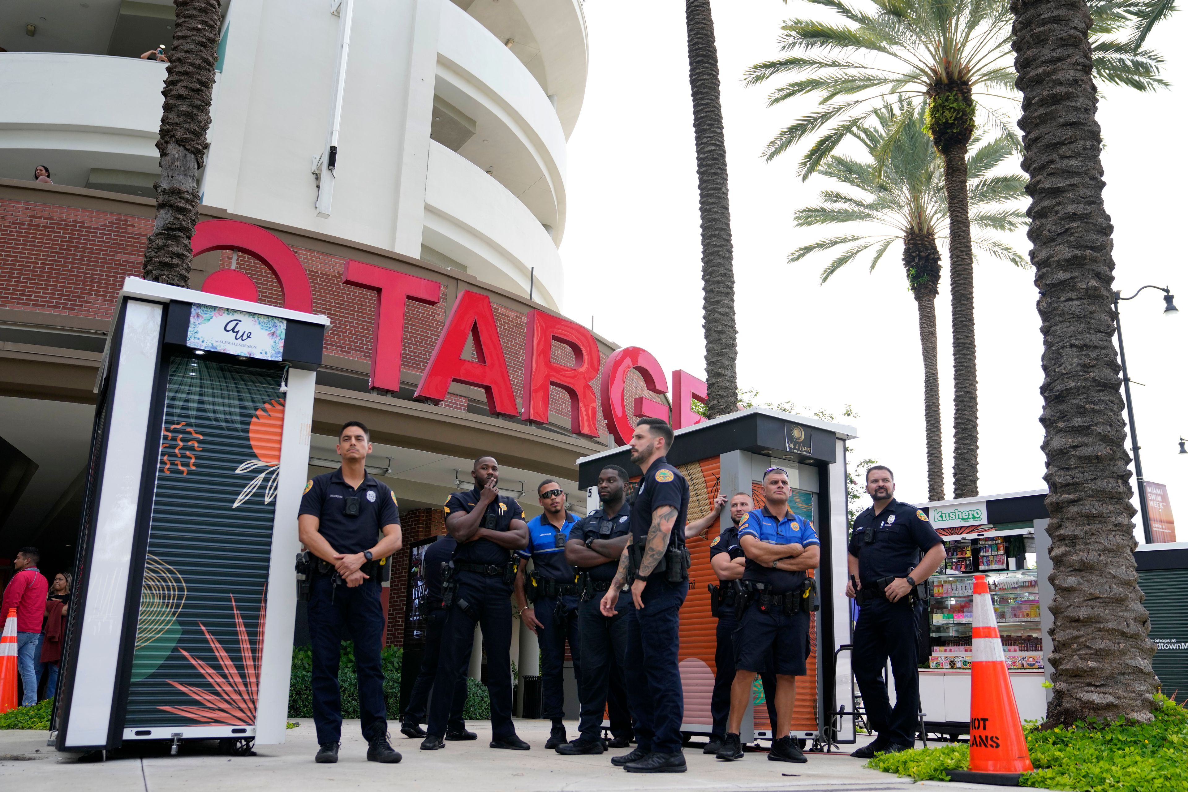 FILE - Police officers stand outside a Target store as a group of people protest across the street, Thursday, June 1, 2023, in Miami. Longtime Pride sponsors like Bud Light and Target have come under attack by conservatives for their LGBTQ-friendly marketing. (AP Photo/Lynne Sladky, File)