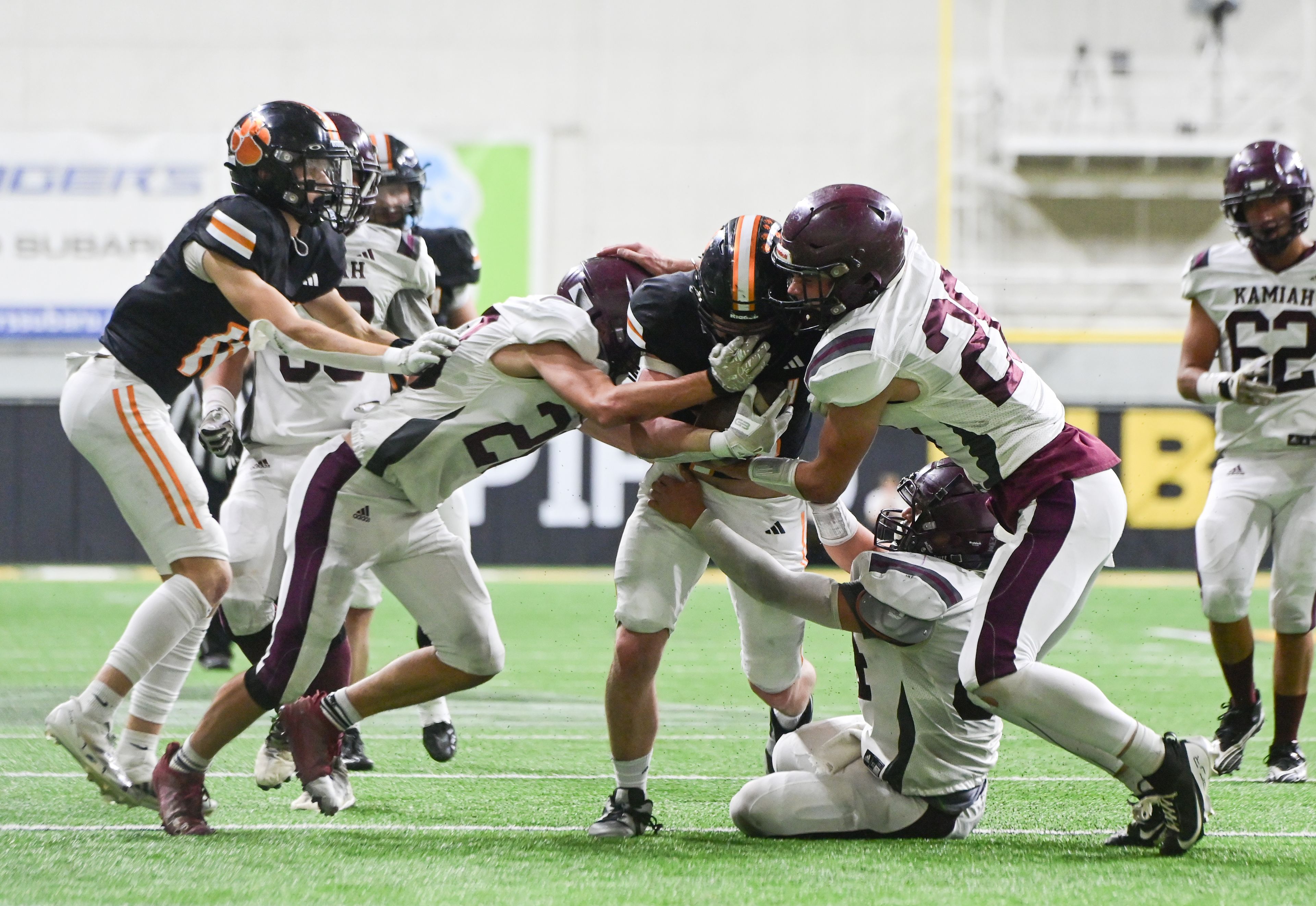 Kendrick’s Xavier Carpenter, center, is tackled by Kamiah defense during an Idaho Class 2A state quarterfinal game at the P1FCU Kibbie Dome in Moscow.