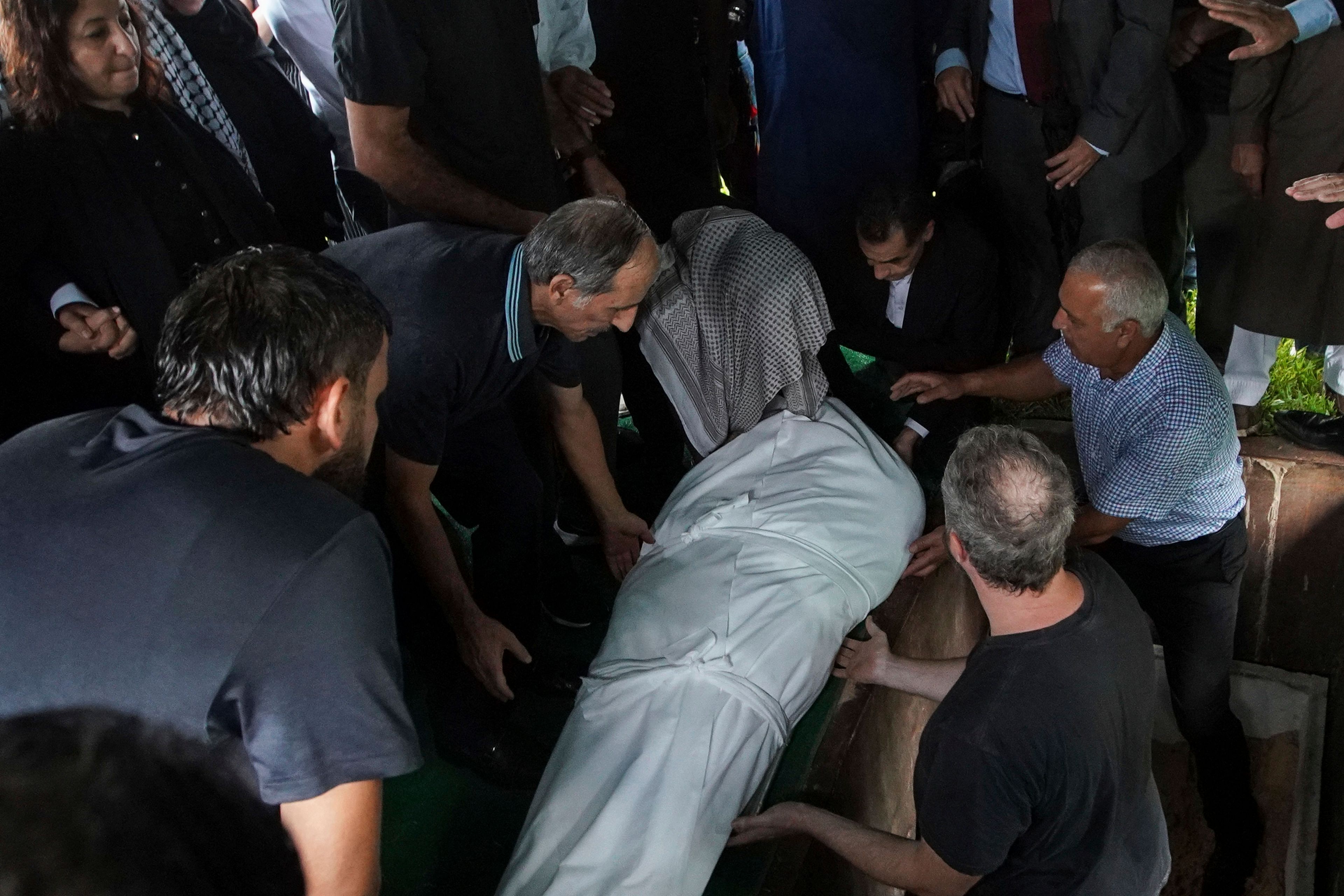 Loved ones lay the body of slain Harris County Precinct 4 Deputy Constable Maher Husseini into the ground for burial, Thursday, Sept. 5, 2024, at Forest Park The Woodlands Funeral Home & Cemetery in The Woodlands, Texas.