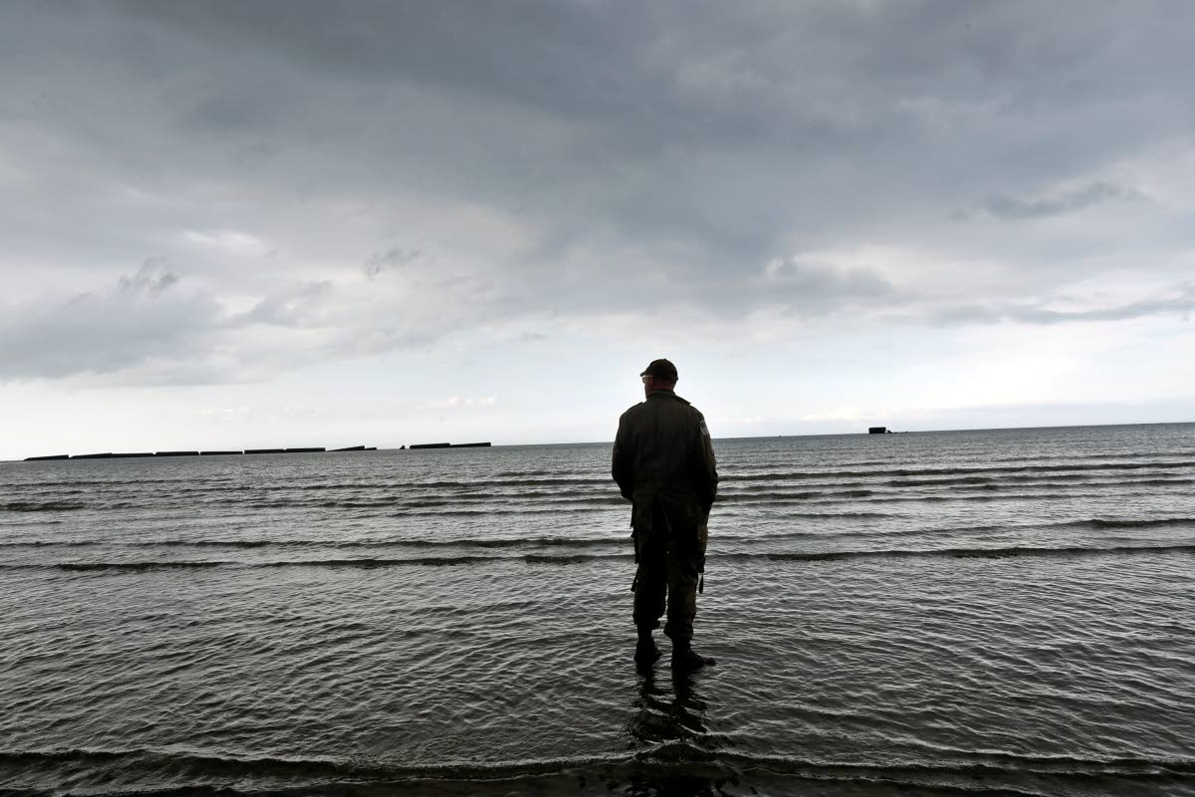 An enthusiast stands on the beach of Arromanches, Tuesday, June 4, 2019 in Normandy. Extensive commemorations are being held in the U.K. and France this week to honor the nearly 160,000 troops from Britain, the United States, Canada and other nations who landed in Normandy on June 6, 1944 in history's biggest amphibious invasion. (AP Photo/Thibault Camus)